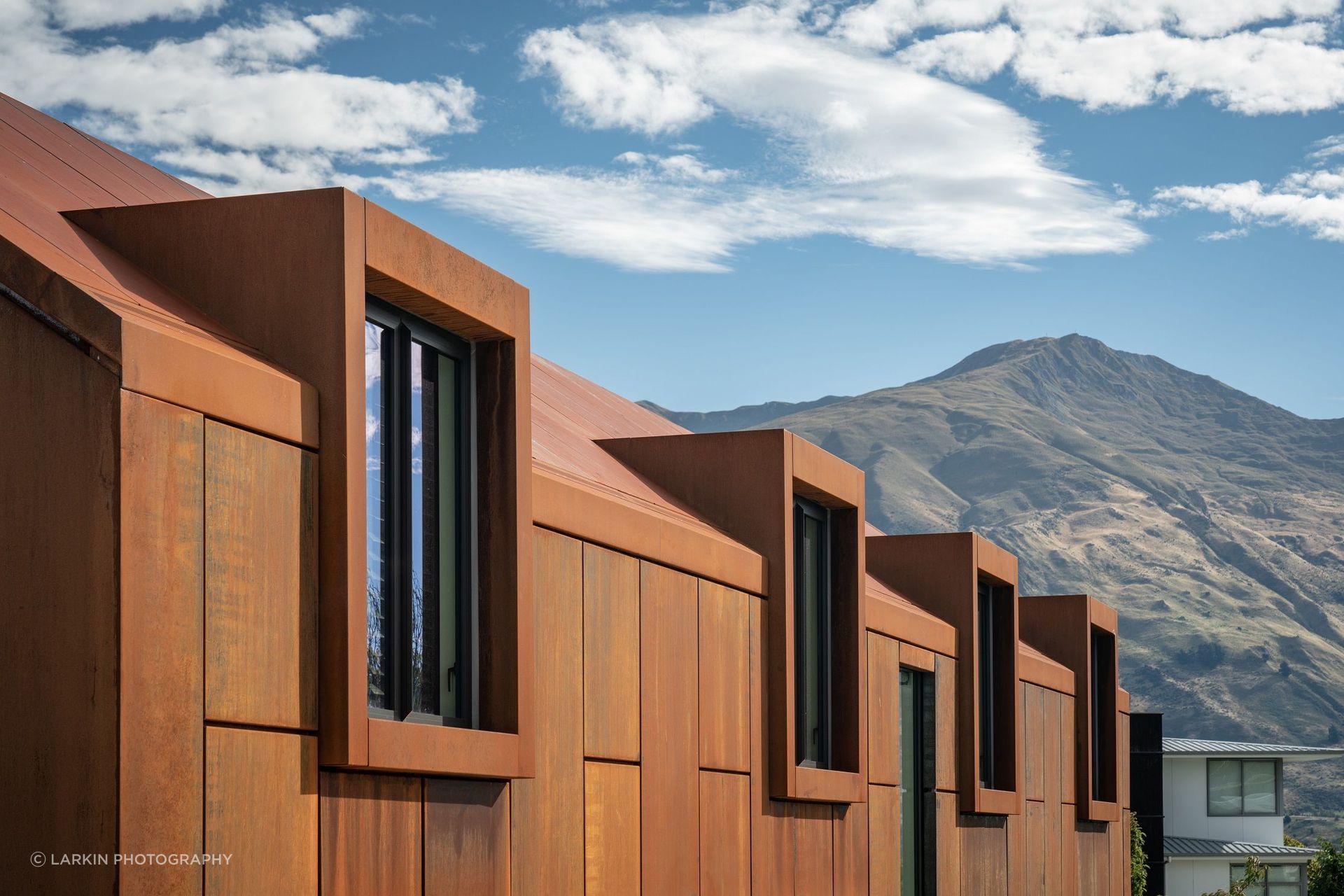 The rich, rusty tones of the corten give warmth to a monolithic building form.