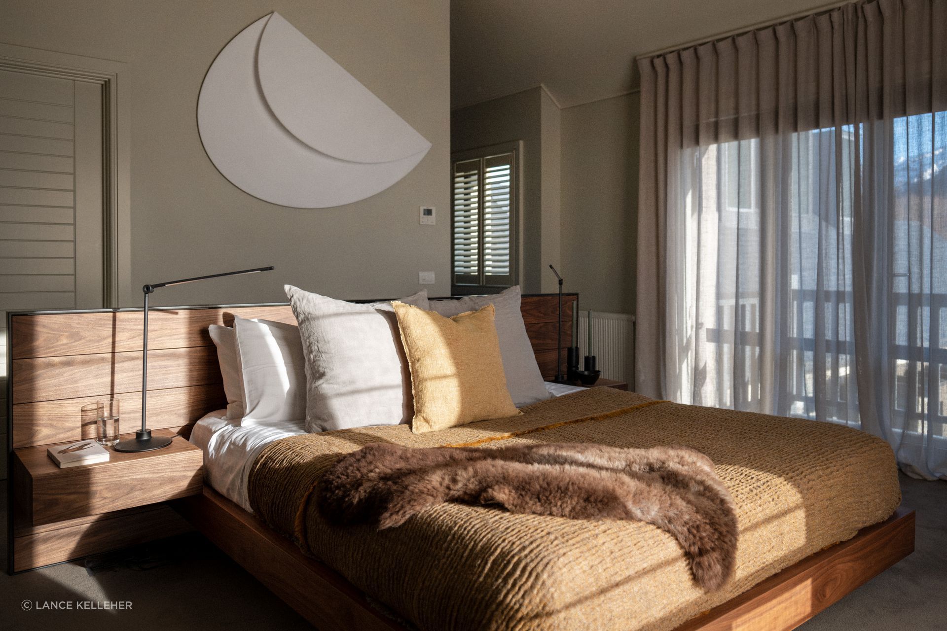 The client's sculptural artwork fits in perfectly in the serene master bedroom on the wall behind the bed; the headboard was moved perpendicular in the final layout, so that the bed faces directly out to the mountain view.