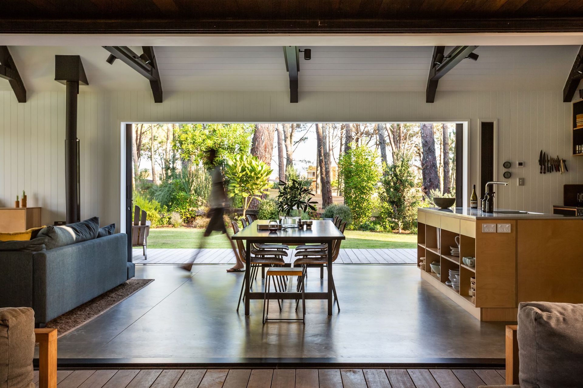 The main living area and kitchen are framed by the trees that define the site and its boundaries.