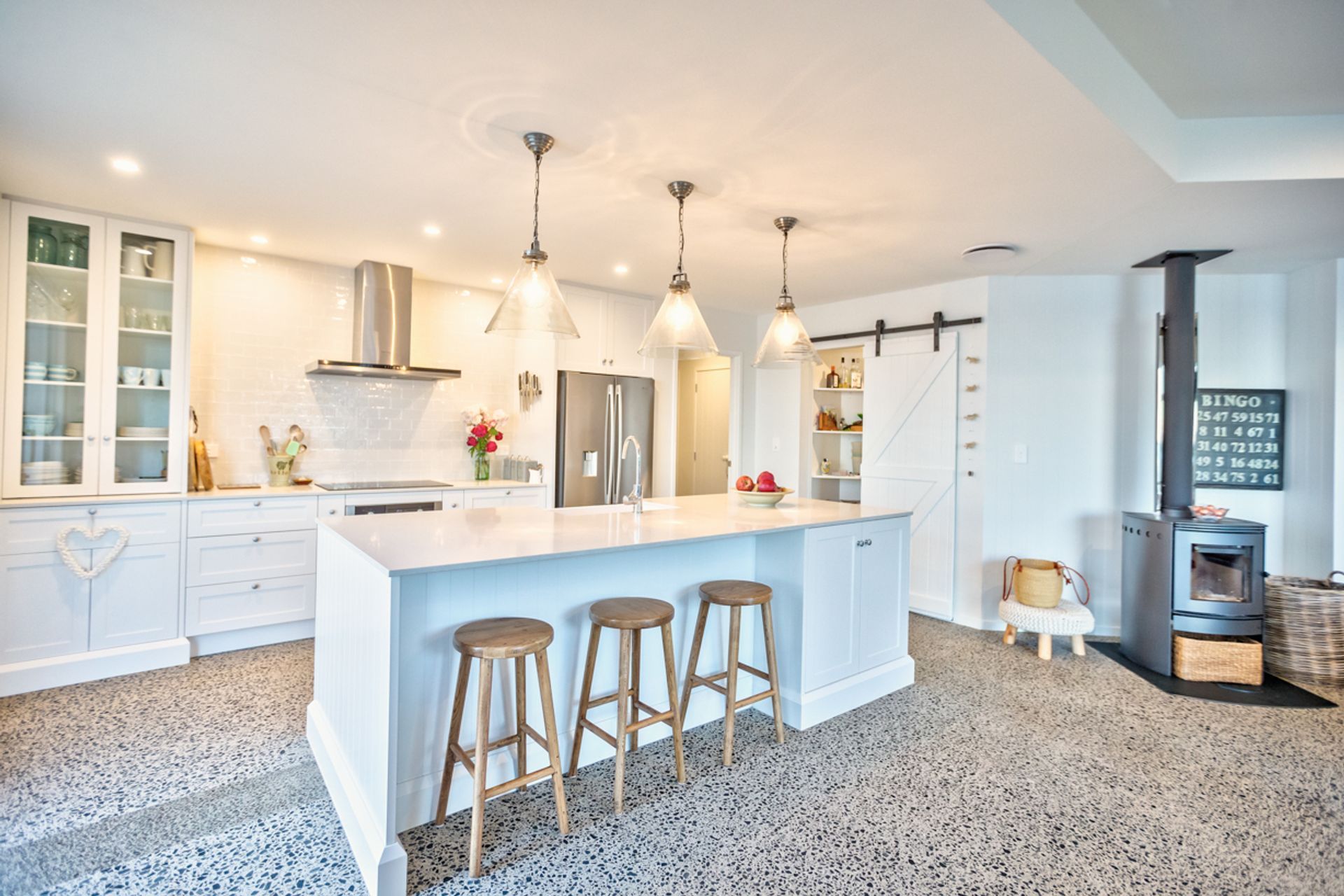 Stunning feature details include the barn door, the library and the central kitchen island. 