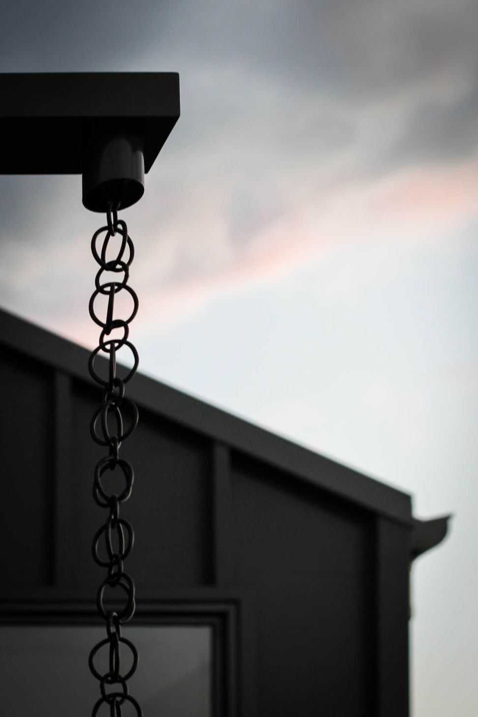Anderson Residence - Exterior. Rain chain hanging from the roof edge.
