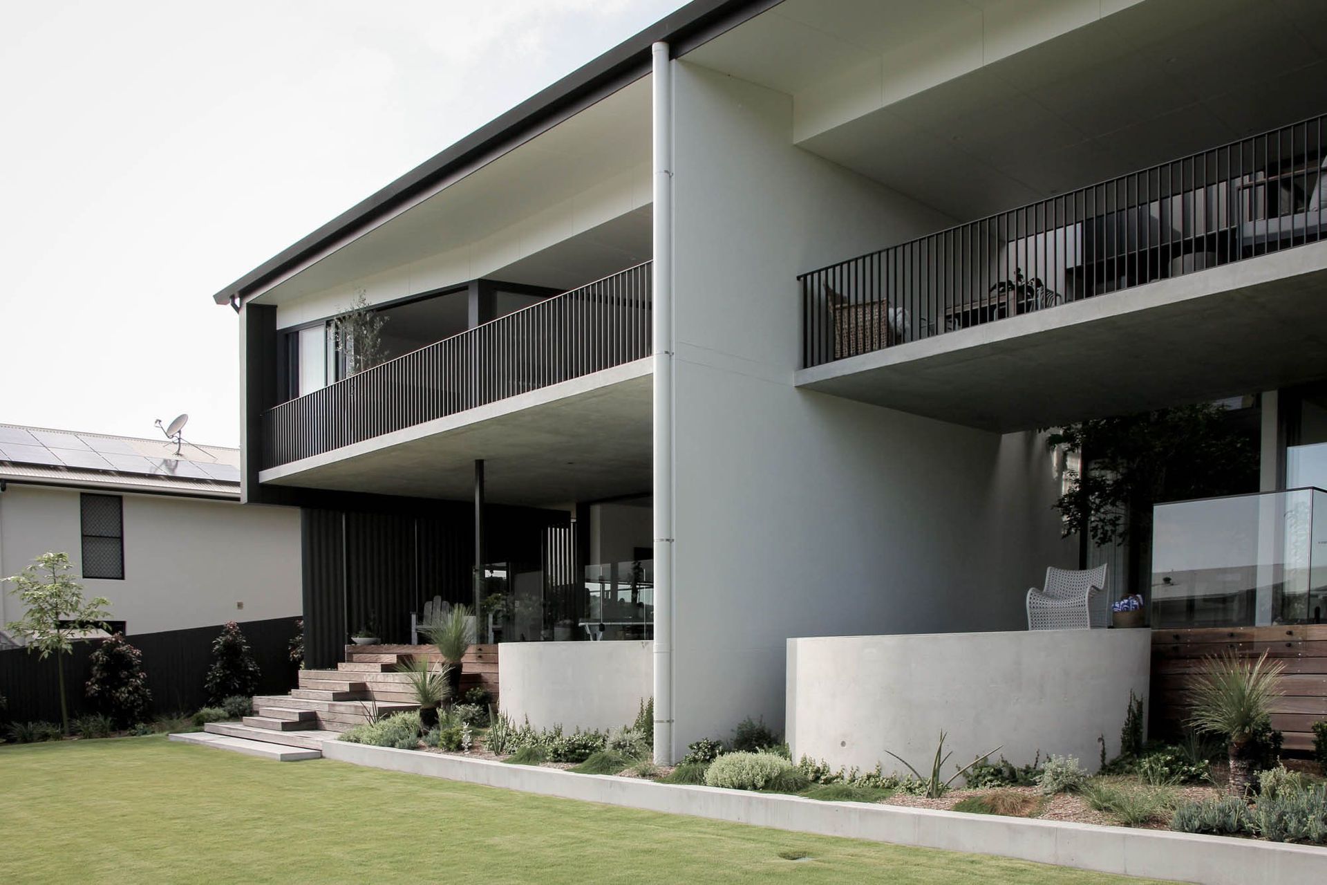 The Dual House - Exterior. Rear of the two homes stepping down to the garden.
