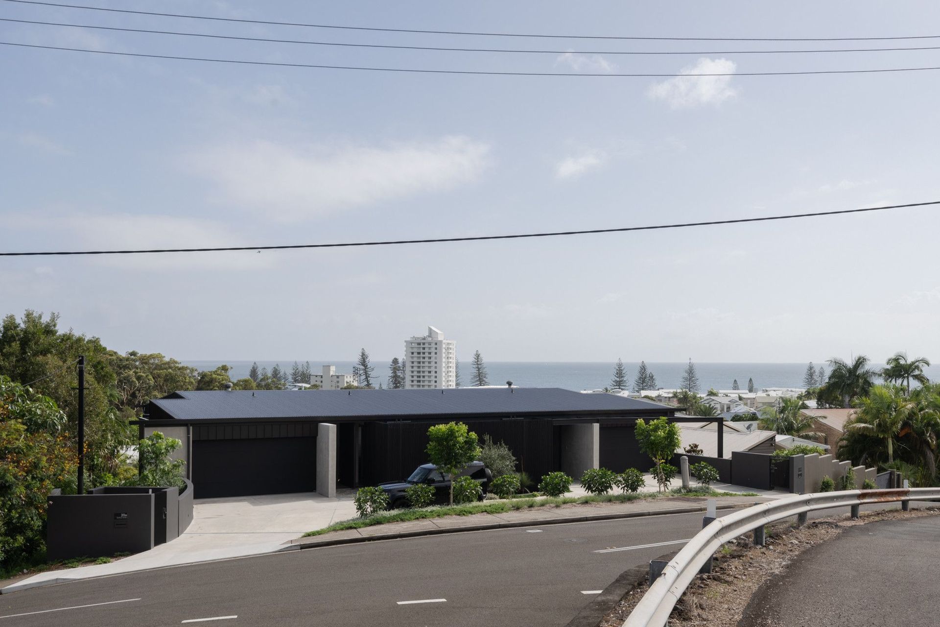 The Dual House - Exterior. The homes on the hillside with ocean views to the horizon.
