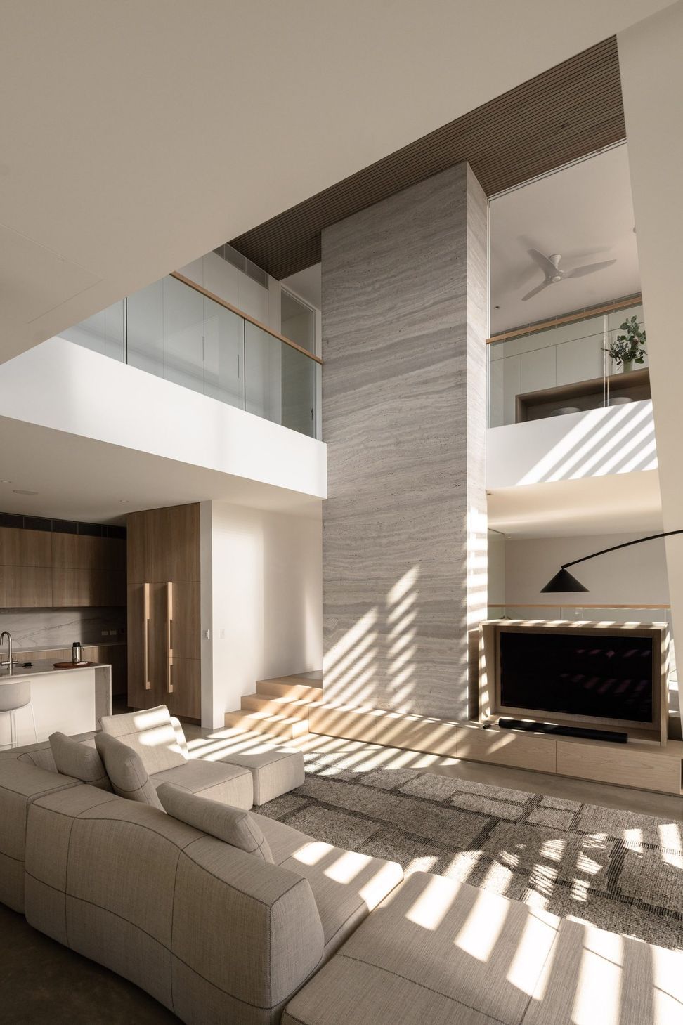 Decade House - Living Room. Afternoon light streaming through the louvres into the double height living room.