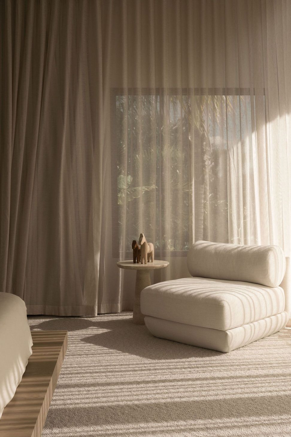 Solmere - Bedroom. Reading corner with a soft lounge chair and sheer curtains.