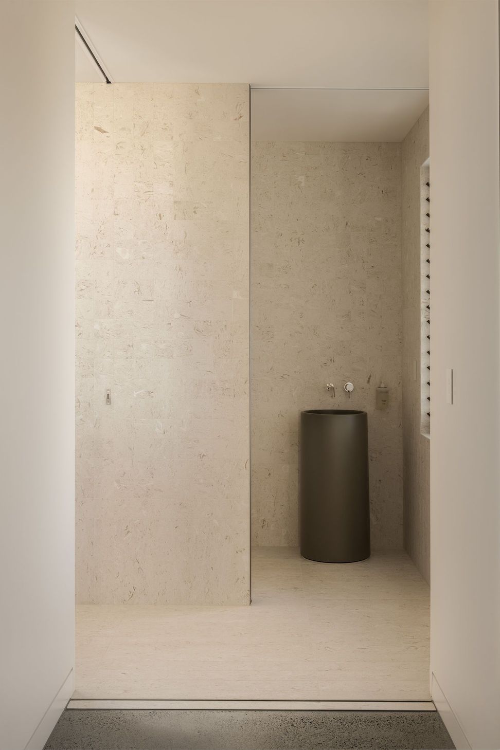 Solmere - Powder Room. Sculptural pedestal basin against a stone wall.