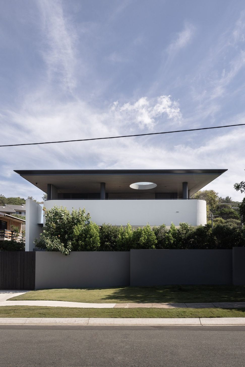 Decade House - Exterior. The home from the street, with its oval skylight cut through the roof.