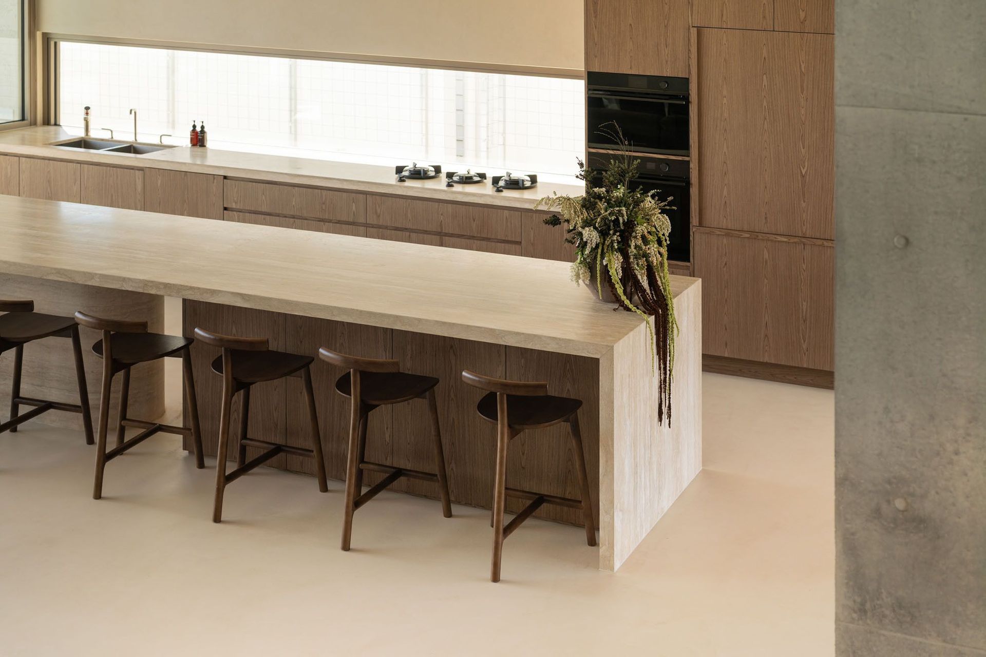 House on Pacific - Kitchen. Kitchen with timber joinery, a long island and a glass fronted wine wall.