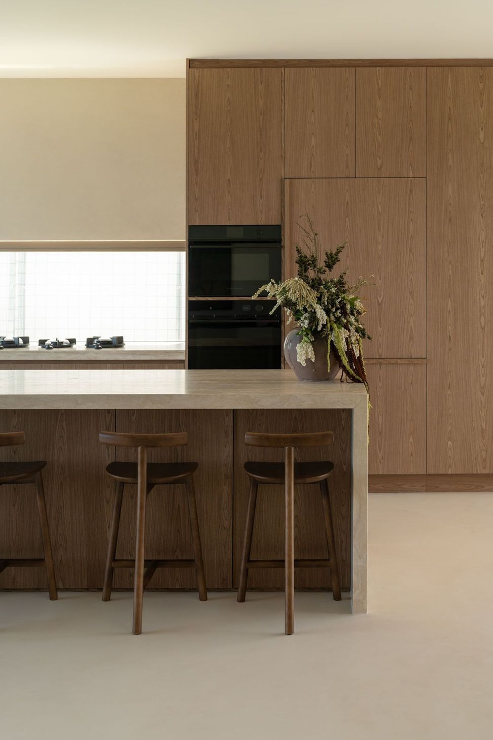 House on Pacific - Kitchen. Timber stools at the stone topped island.