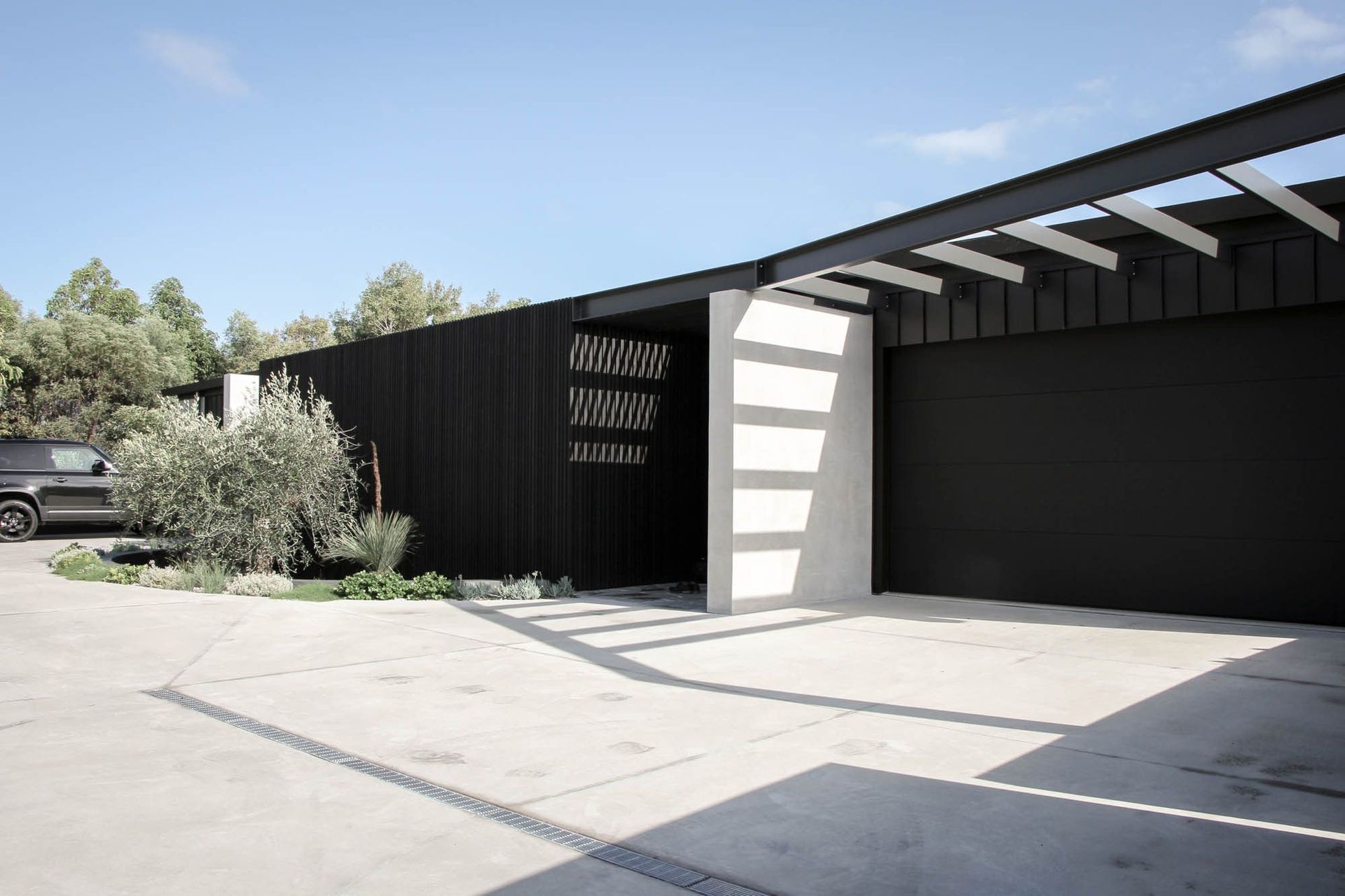 The Dual House - Exterior. Driveway approach to the black clad street frontage.