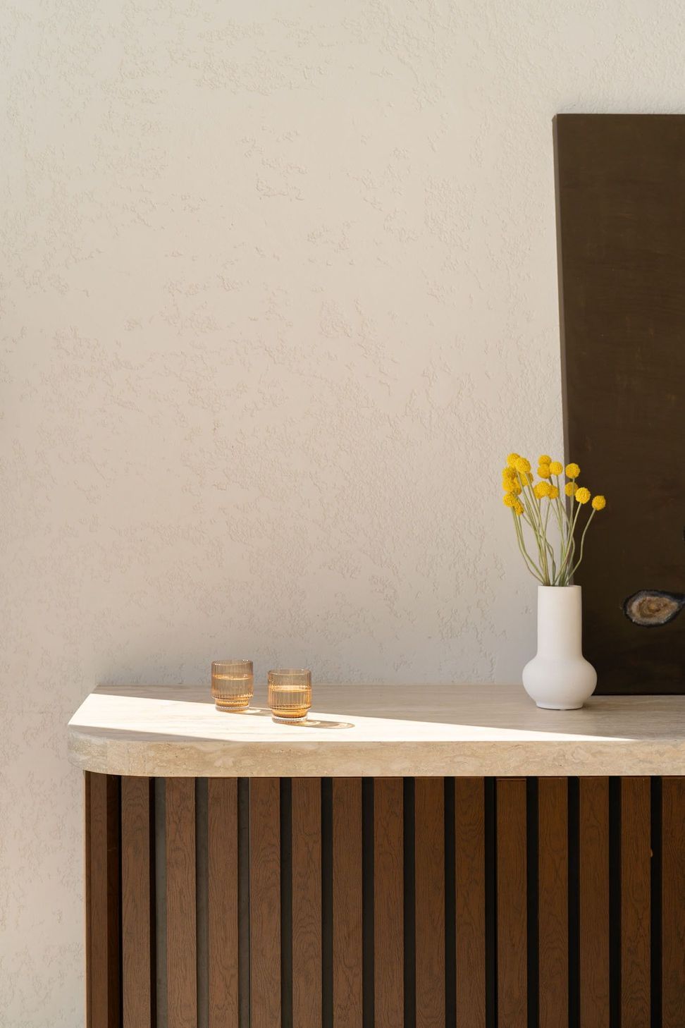 House on Pacific - Bathroom. Floating timber shelf with a vase of flowers.