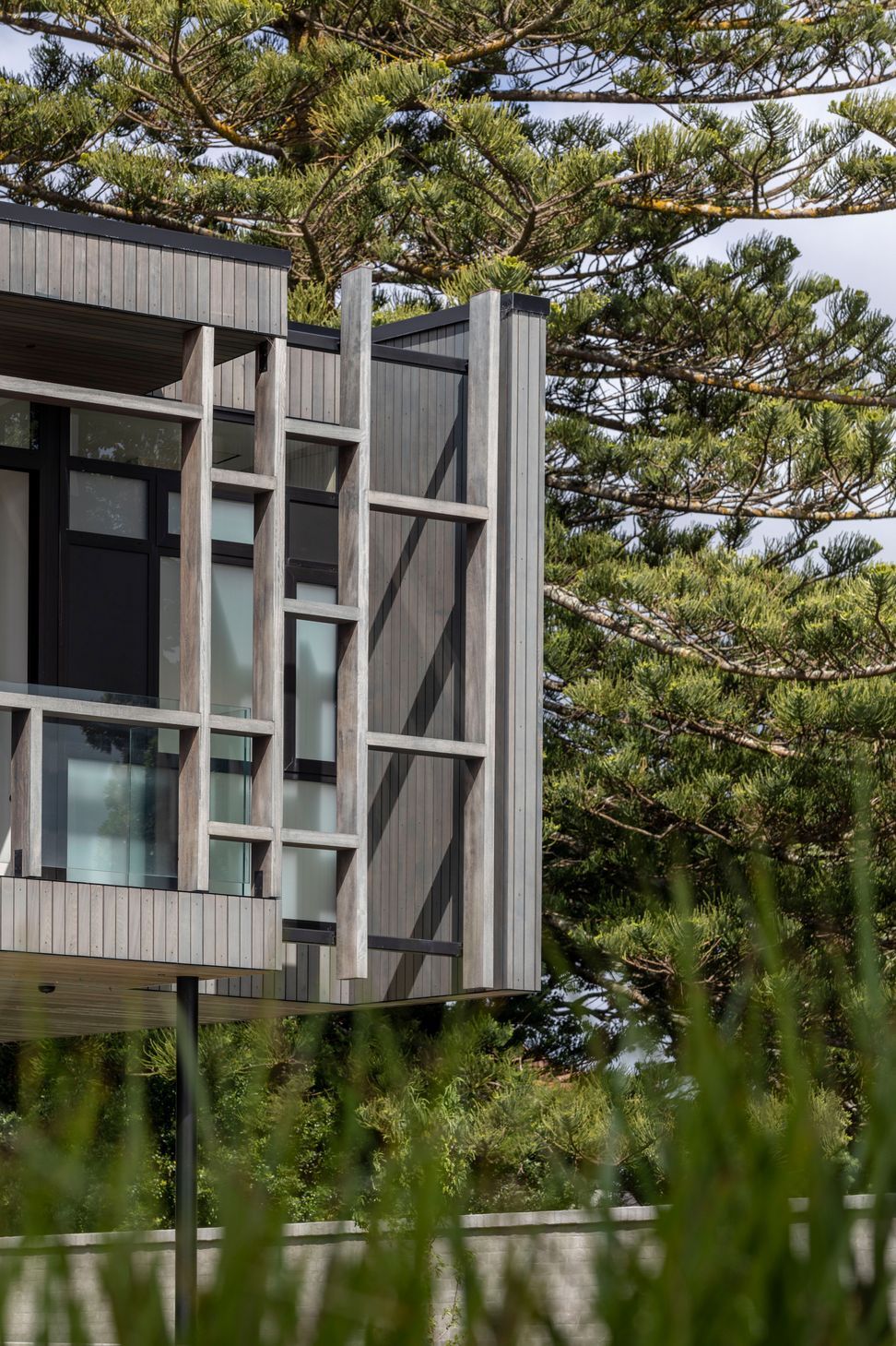 The exterior material palette references the subdued tones of the beach.