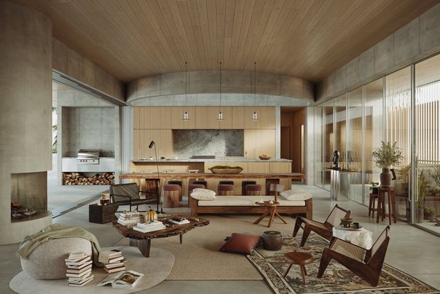 A spacious, refined open-plan living and kitchen interior with exposed concrete walls and beams, warm timber ceiling and cabinetry, a large kitchen island, extensive floor-to-ceiling glazing, and layered mid-century-inspired furniture. The room includes a sunken or informal lounge area, a dining or living zone, a fireplace with stacked firewood, and abundant natural light.