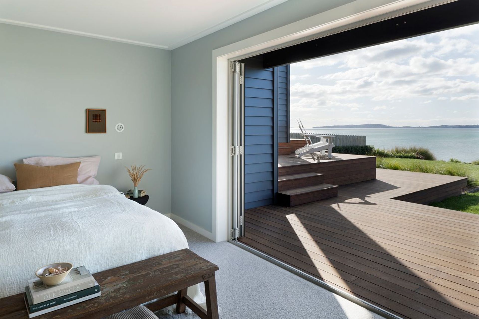 A bank of bifold doors provides seamless egress to the outdoors from this bedroom suite. An elevated viewing platform is the ideal spot to watch the world go by.
