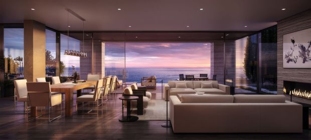 A luxurious open-plan living and dining room with expansive floor-to-ceiling glazing overlooking the ocean at sunset. The room features a large neutral sectional sofa, contemporary dining table and chairs, dark timber flooring, recessed ceiling lighting, a linear fireplace integrated into a dark feature wall, and a refined palette of taupe, beige, brown, and charcoal tones.