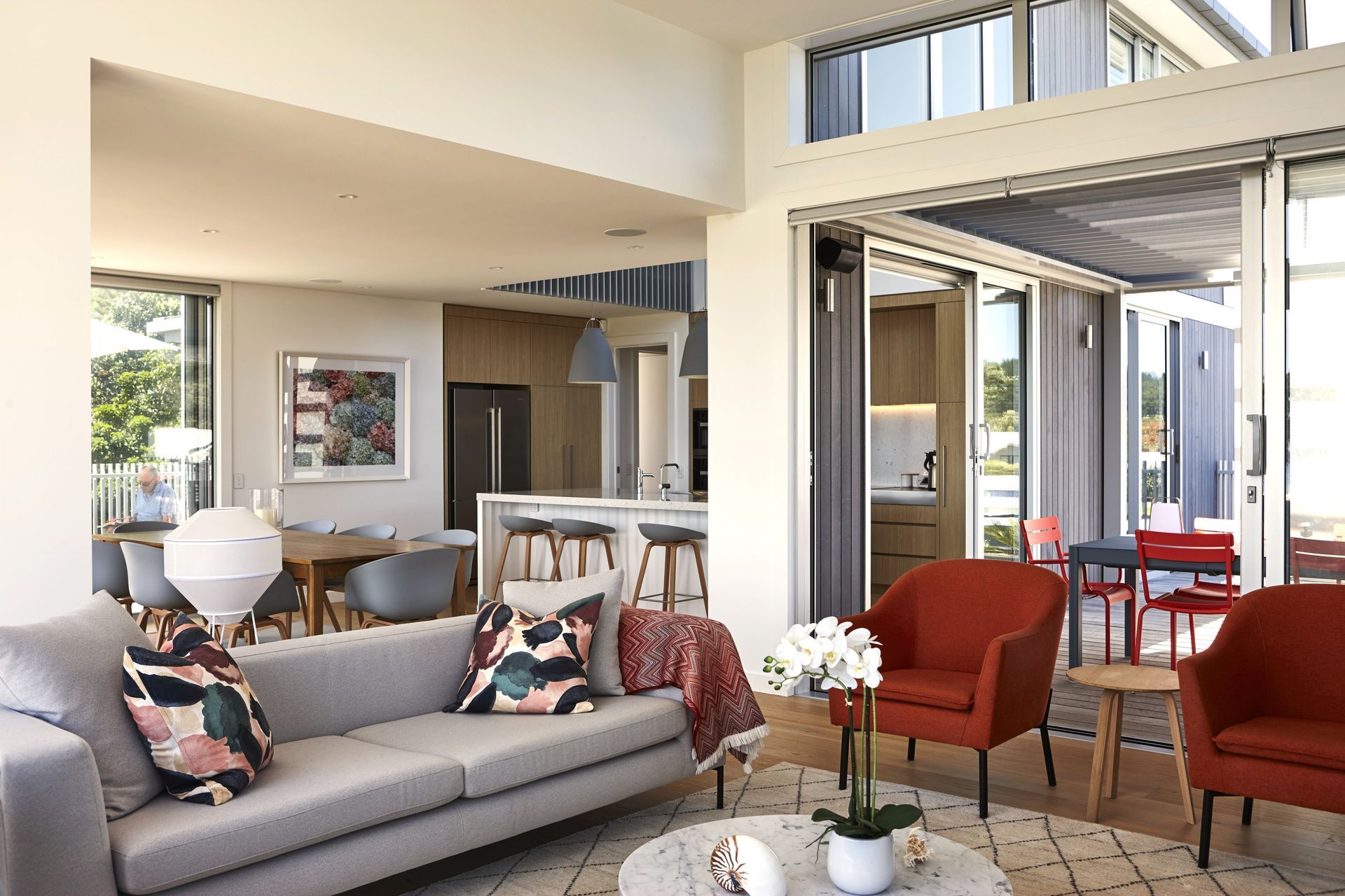 Looking back through the open-plan living spaces, the dining room and kitchen connect effortlessly to the covered outdoor dining area. The carefully planned layout encourages entertaining while maintaining strong visual links to the surrounding landscape.