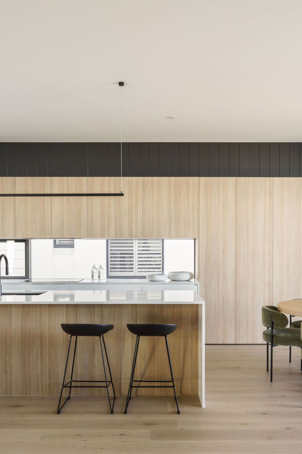 Gilbert Residence - Kitchen. Timber cabinetry and a white island with a slim pendant.