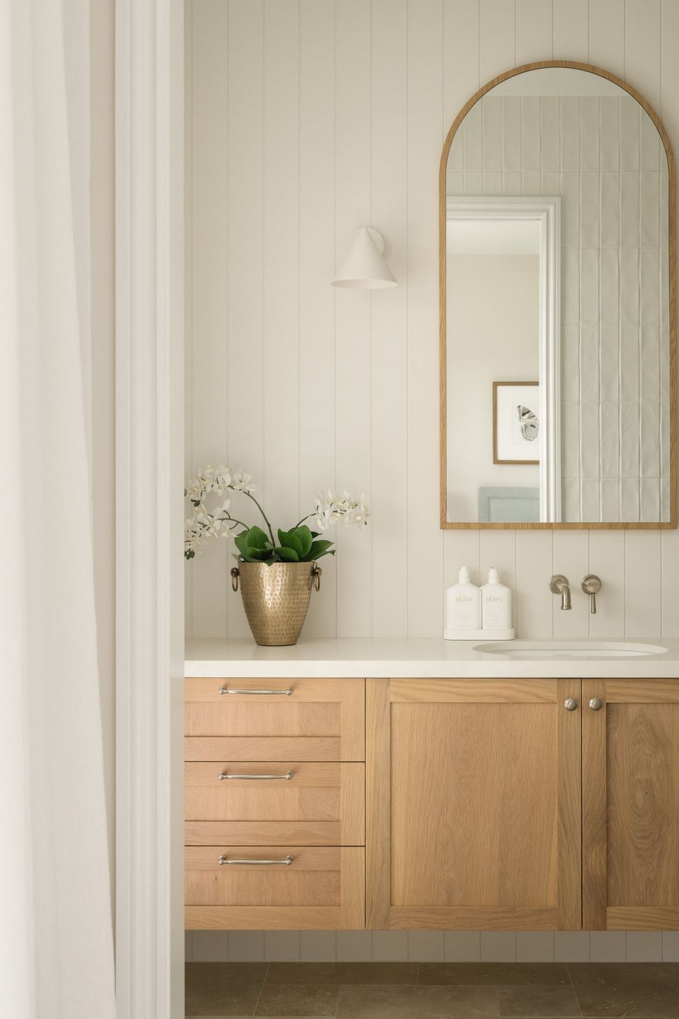 Euroa Farm - Bathroom. Timber vanity and arched mirror with brushed tapware.