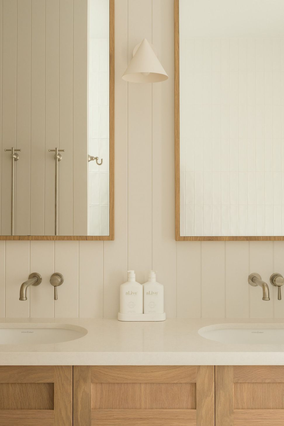 Euroa Farm - Bathroom. Brushed wall mounted tapware beneath timber framed mirrors.