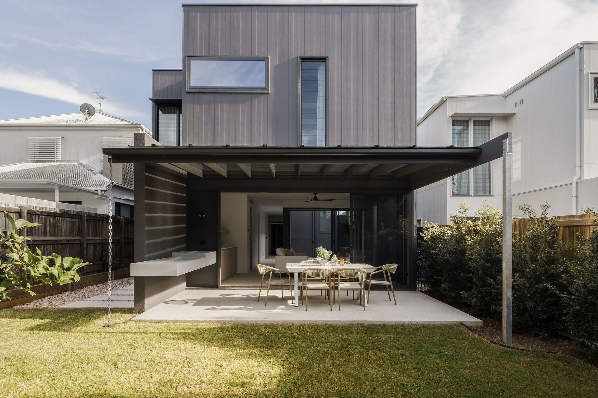 Gilbert Residence - Exterior. Rear elevation with a covered terrace and outdoor dining.