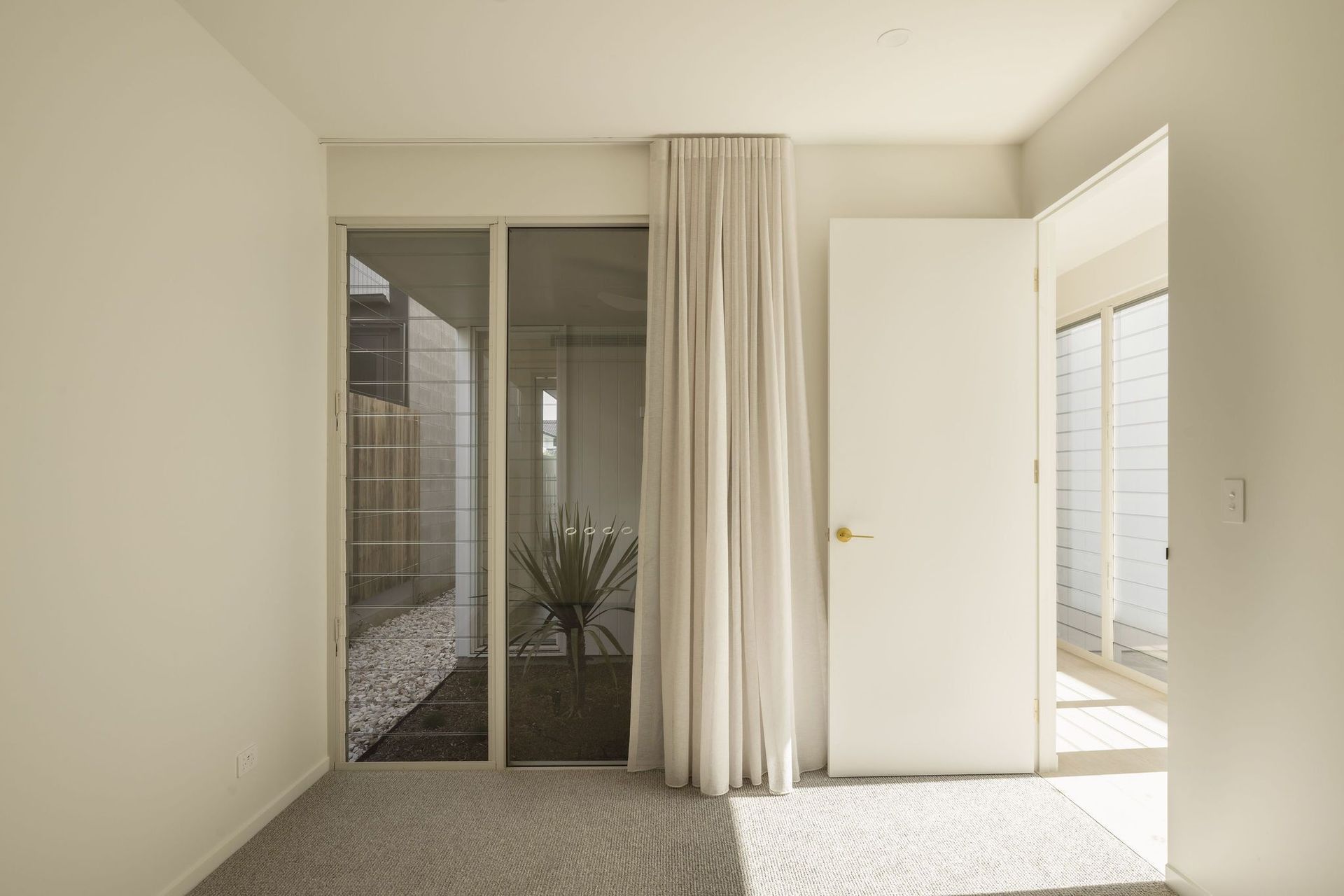 Gilbert Residence - Hall. Hallway opening to the garden through glazed doors.