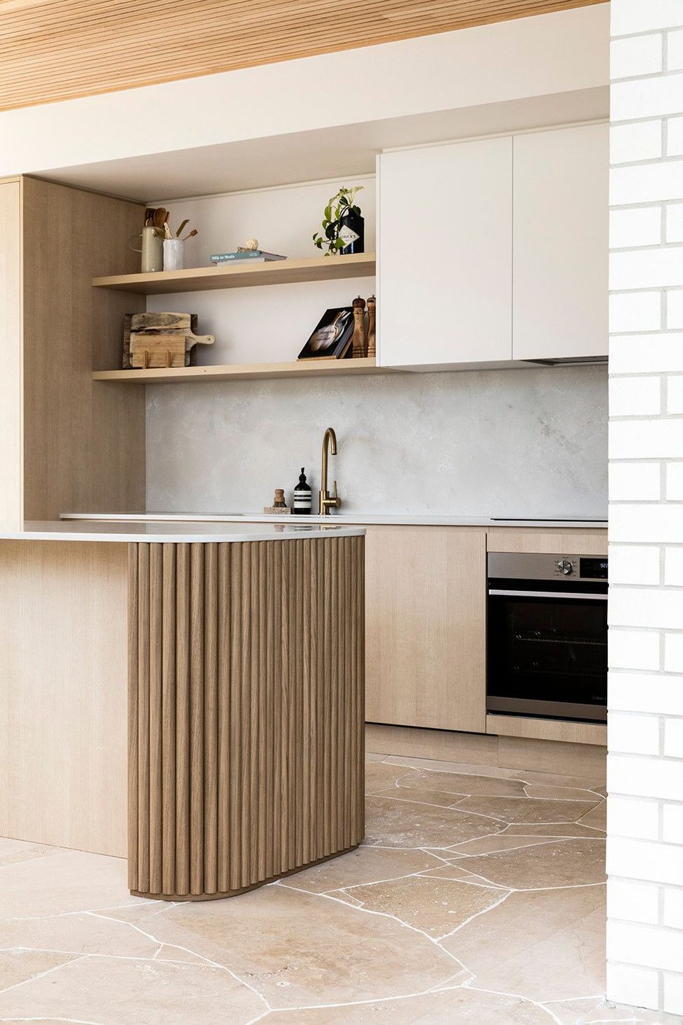 Viner Residence - Kitchen. Curved island with timber battens and brass tapware.
