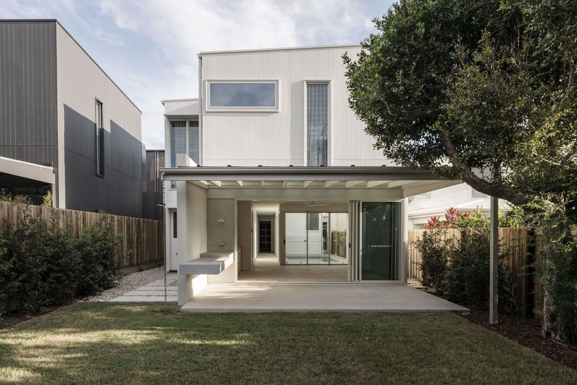 Gilbert Residence - Exterior. Rear elevation and garden with a covered terrace.