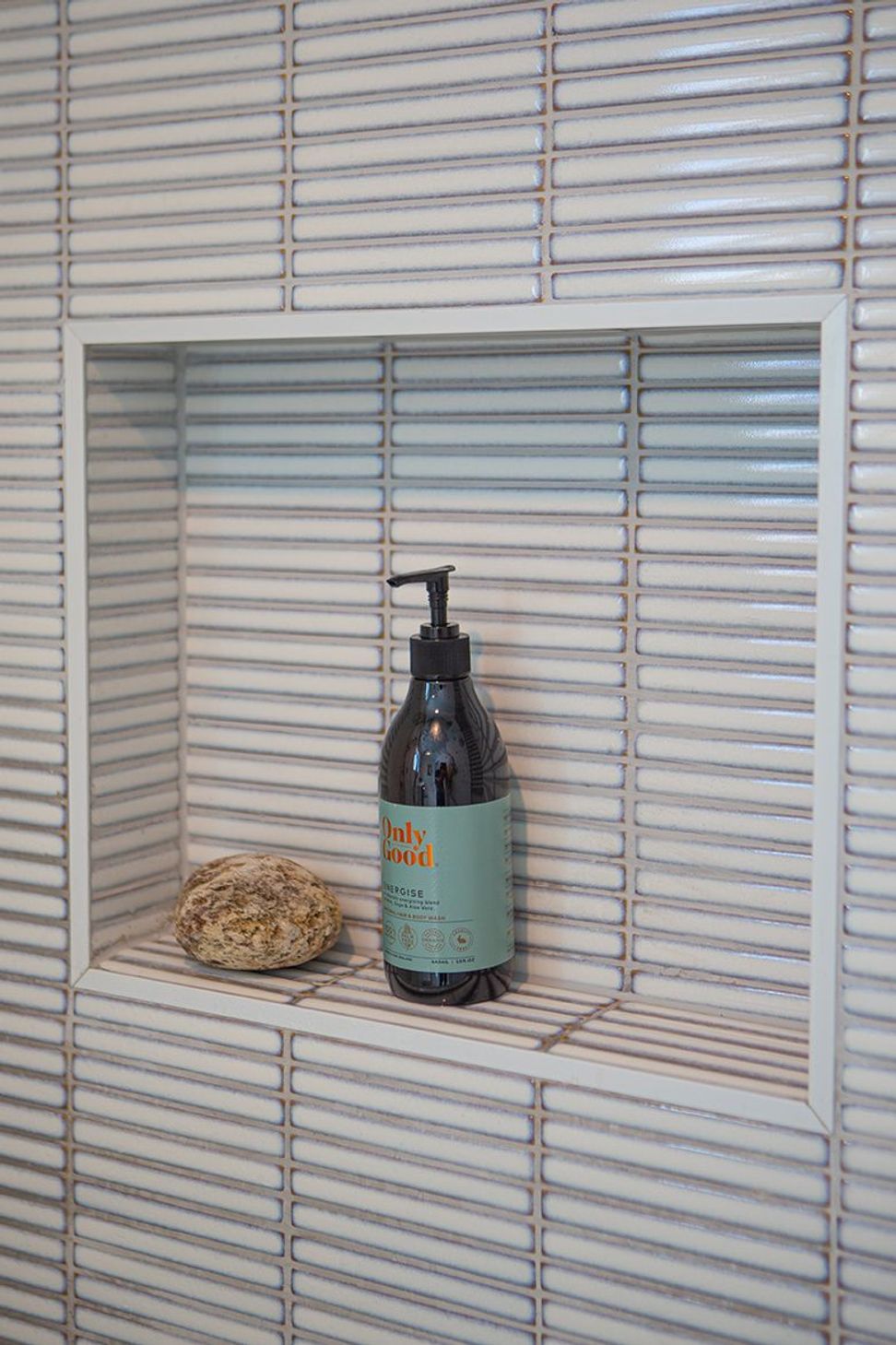 Recessed tiled shower niche.