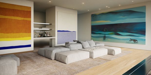 A spacious contemporary living room with a large low-profile modular sectional arranged around an open floor area. The room features pale timber flooring, a large textured neutral rug, recessed ceiling lighting, integrated open shelving with a small bar display, and prominent abstract artworks in warm ochre tones and cool blue-green tones. The space has a refined, gallery-like atmosphere with clean built-in surfaces and expansive artwork.