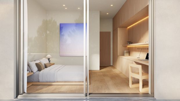 A modern bedroom viewed through full-height glazed sliding doors, with a neatly made bed on the left and a warm timber built-in study nook and shelving on the right. Pale walls, timber flooring, recessed ceiling lights, and concealed LED strip lighting create a clean, understated interior.