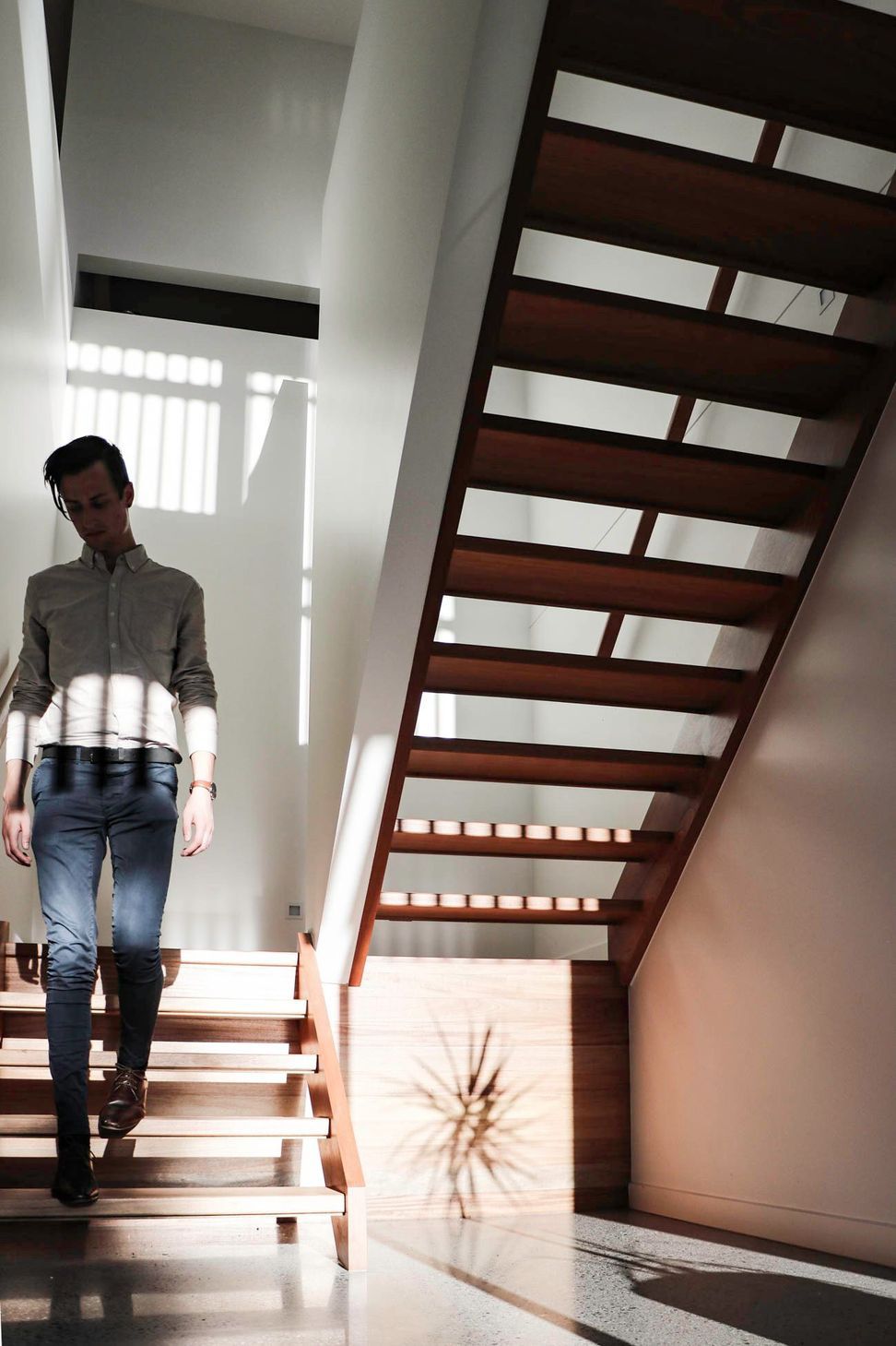 Glennon Residence - Staircase. Open riser timber stair against a white wall.
