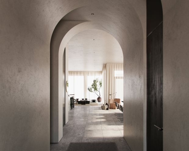 A softly lit interior view through a series of curved, plastered archways into an open-plan living and dining area. The space features pale stone or concrete-look flooring, warm off-white textured walls and ceilings, sheer floor-to-ceiling curtains, minimal furniture, and dark timber or black joinery at the right edge. The composition creates a calm, refined and sculptural atmosphere.