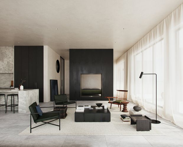 A refined open-plan living room with a minimalist, dark-toned fireplace wall and large floor-to-ceiling windows draped in sheer curtains. The room includes a low black coffee table, sculptural lounge chairs, a timber-framed armchair, a pale area rug, and a partial kitchen with a stone island and black cabinetry. Pale large-format flooring and a textured light ceiling create a bright, gallery-like interior with strong contrast from the dark joinery and fireplace surround.