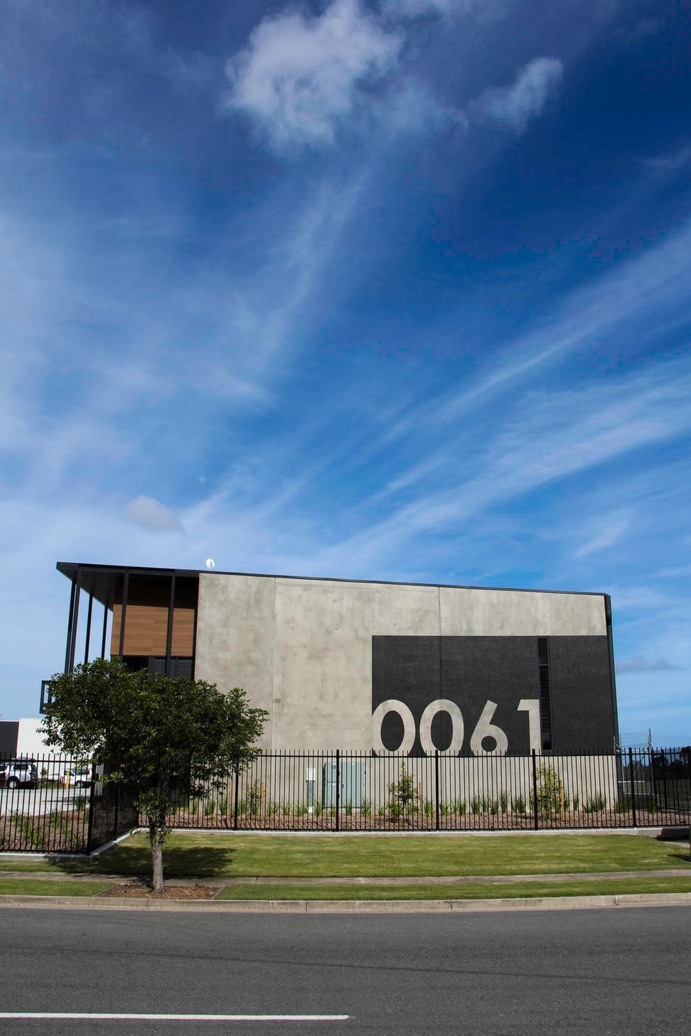 Eniquest Warehouse - Exterior. Concrete panel facade with a timber screened office above.