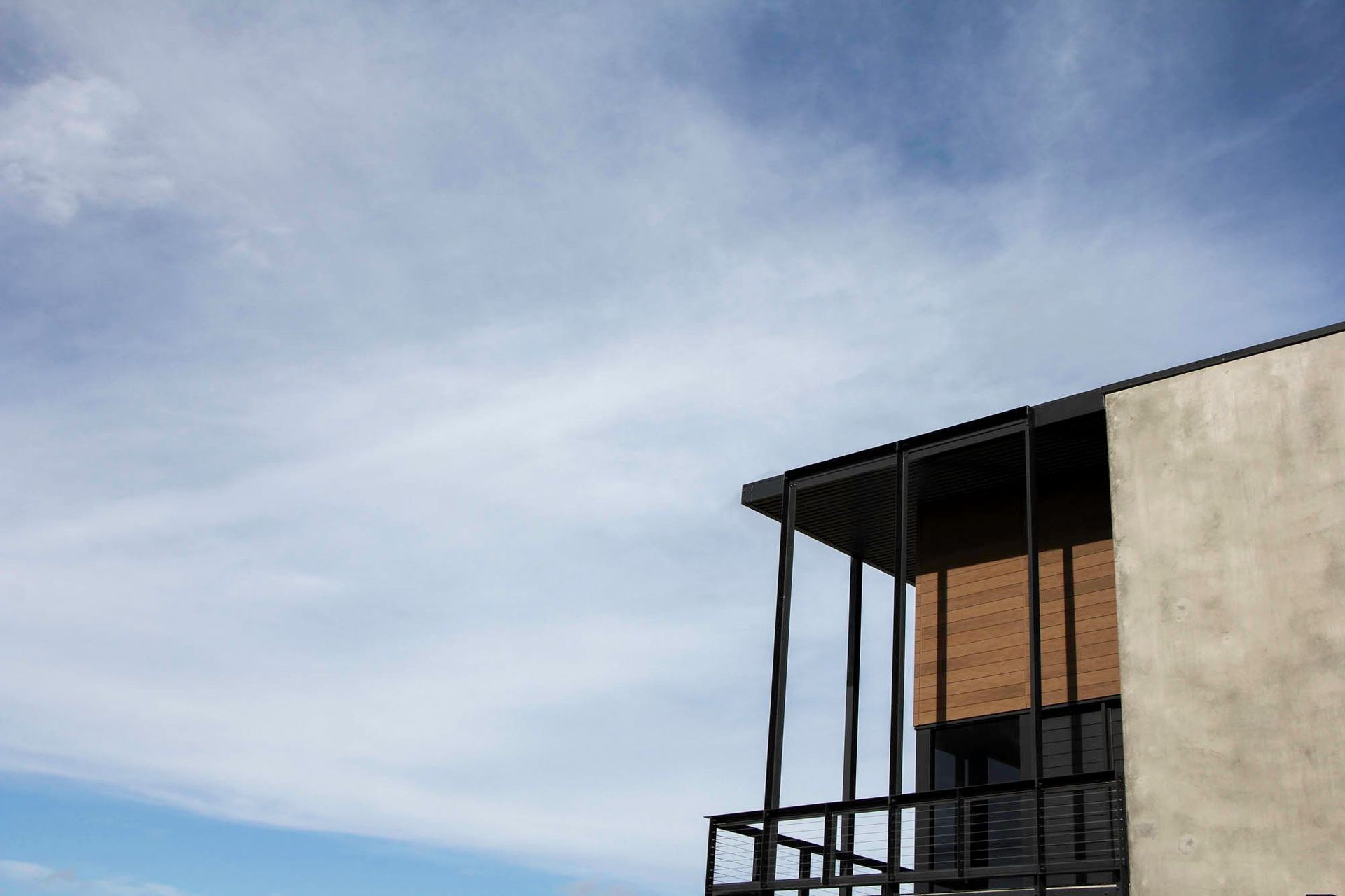 Eniquest Warehouse - Exterior. Timber screened office pavilion against the sky.