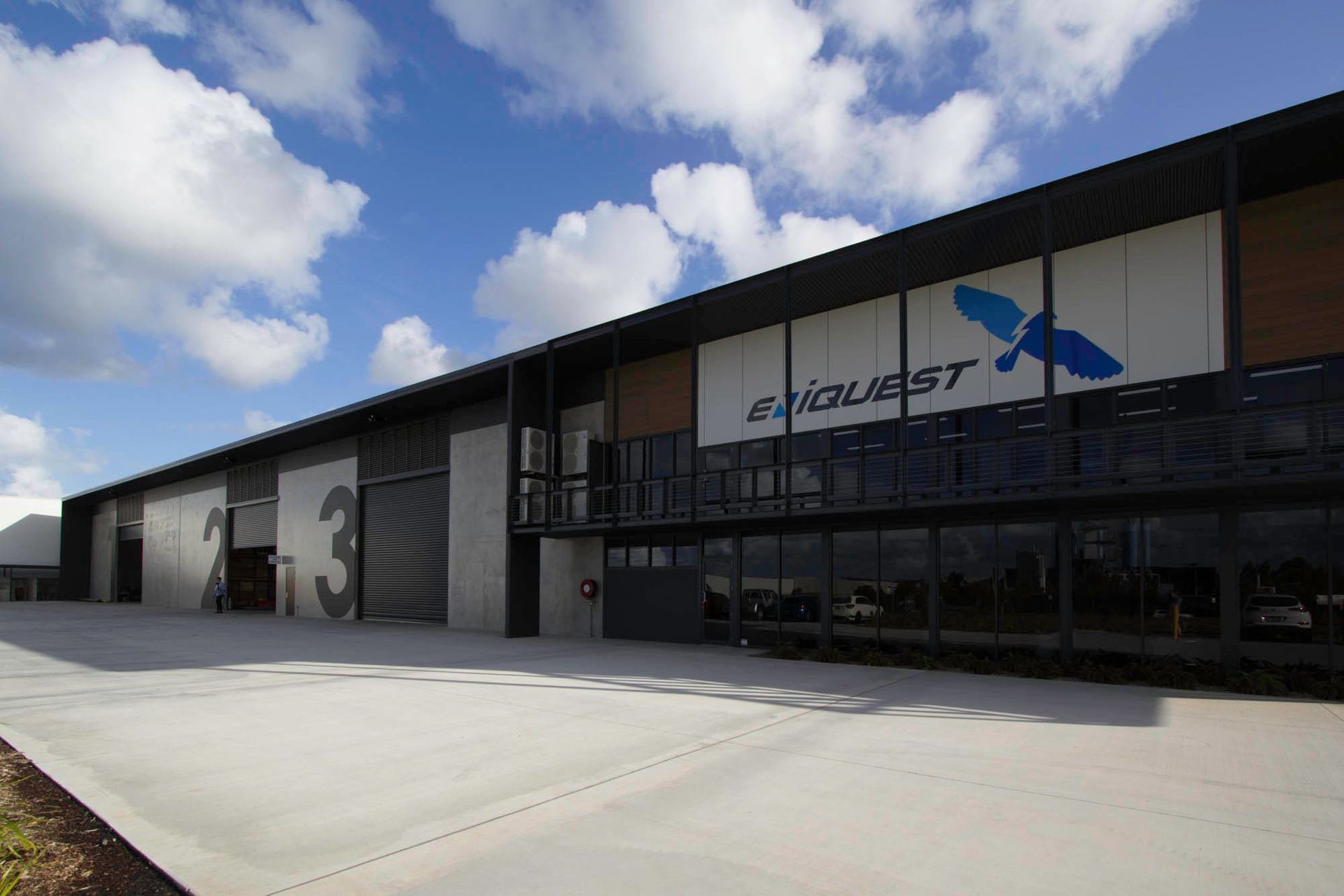 Eniquest Warehouse - Exterior. Signage along the dark clad warehouse.