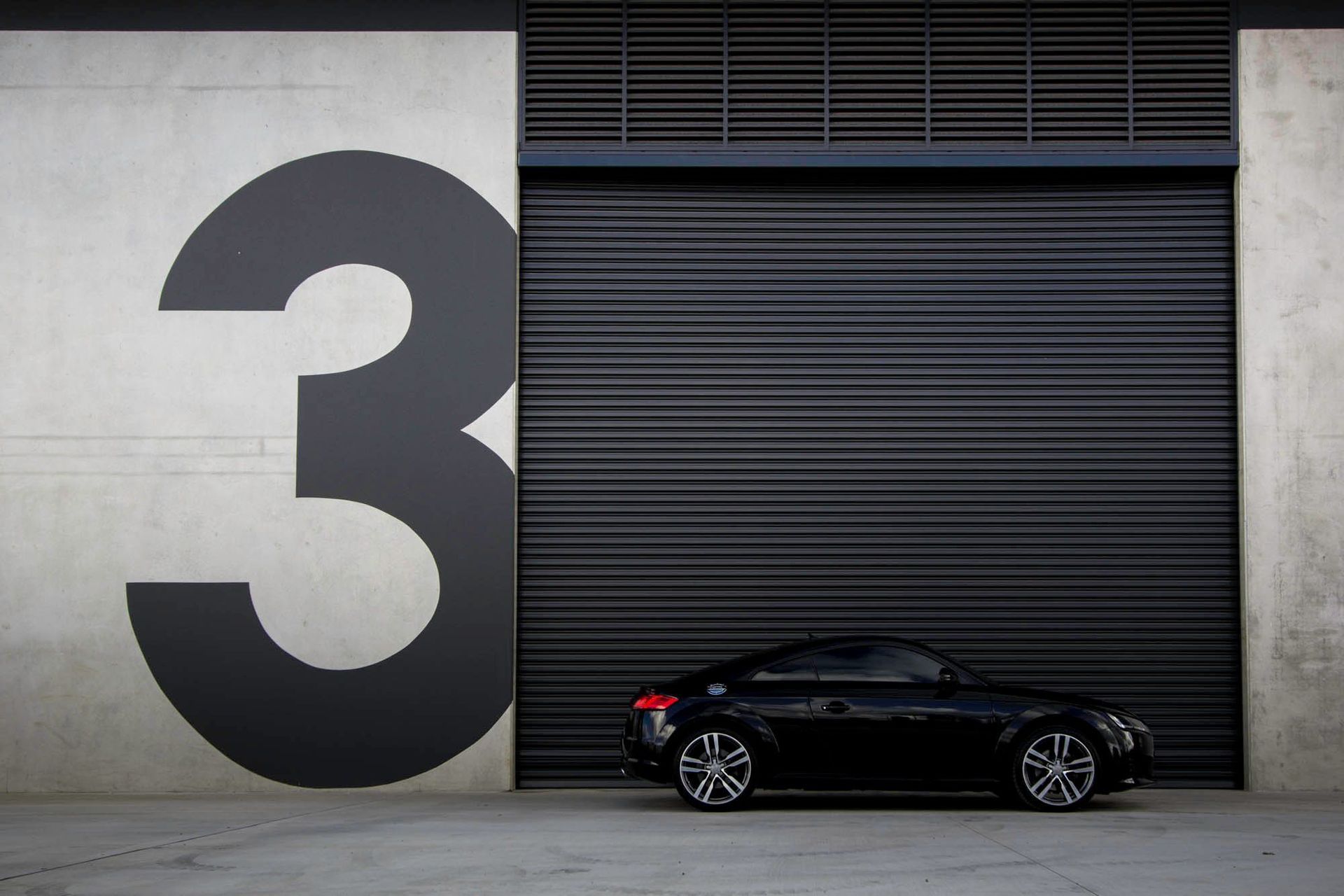 Eniquest Warehouse - Exterior. Tenancy number beside a black roller door.