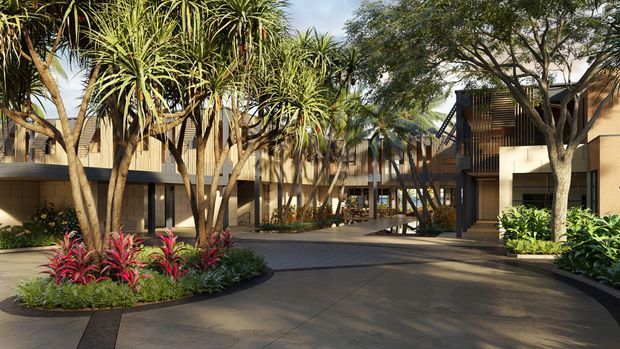 A landscaped courtyard and driveway approach to a contemporary multi-storey building, with warm timber-toned cladding, dark-framed glazing, covered walkways, and lush tropical planting including sculptural trees and red-leaved groundcover. The composition emphasizes the building’s communal outdoor forecourt and architectural connections between wings.