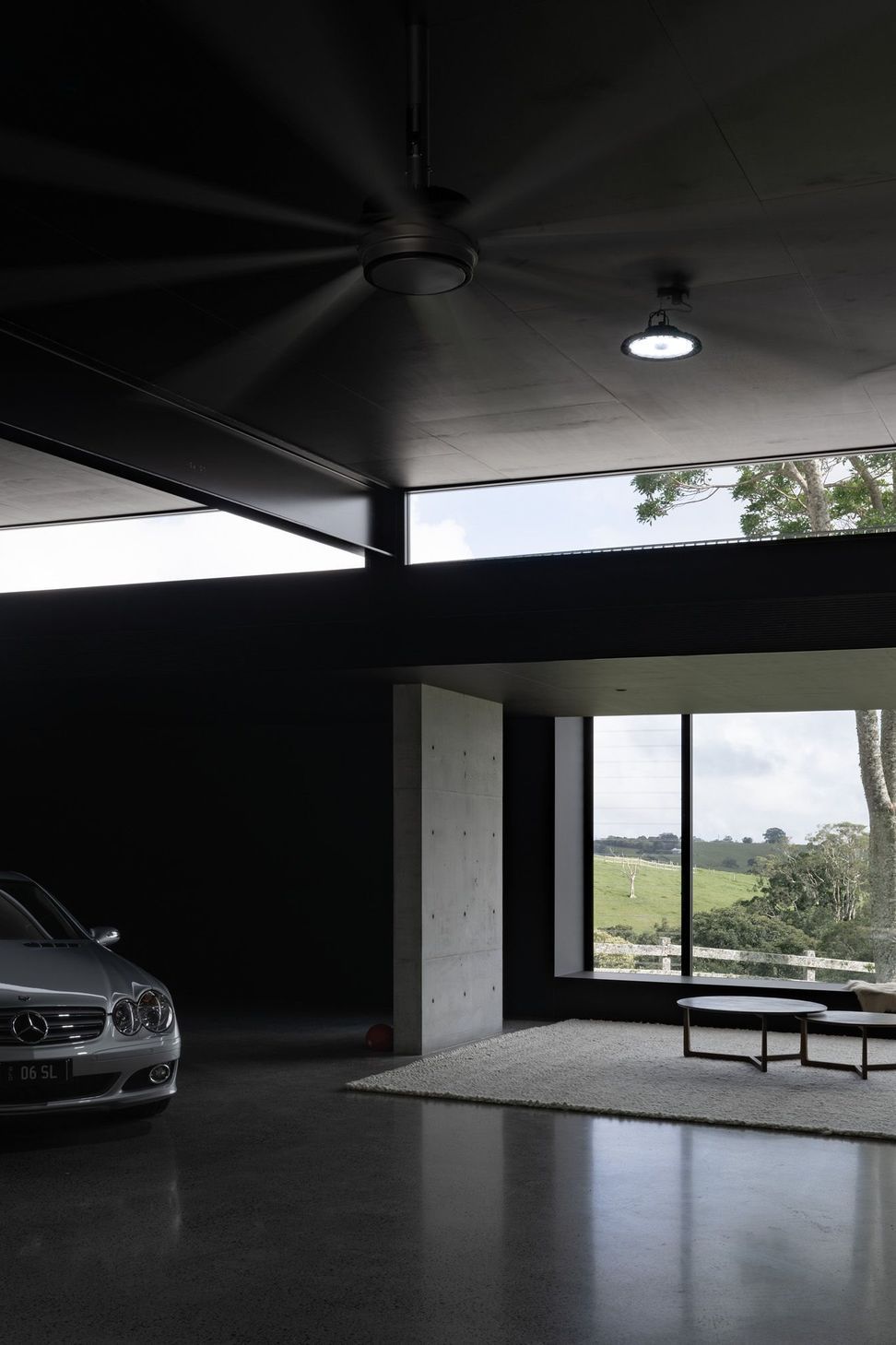 The Farm - Garage. Dark ceiling and glazing opening to paddock views.