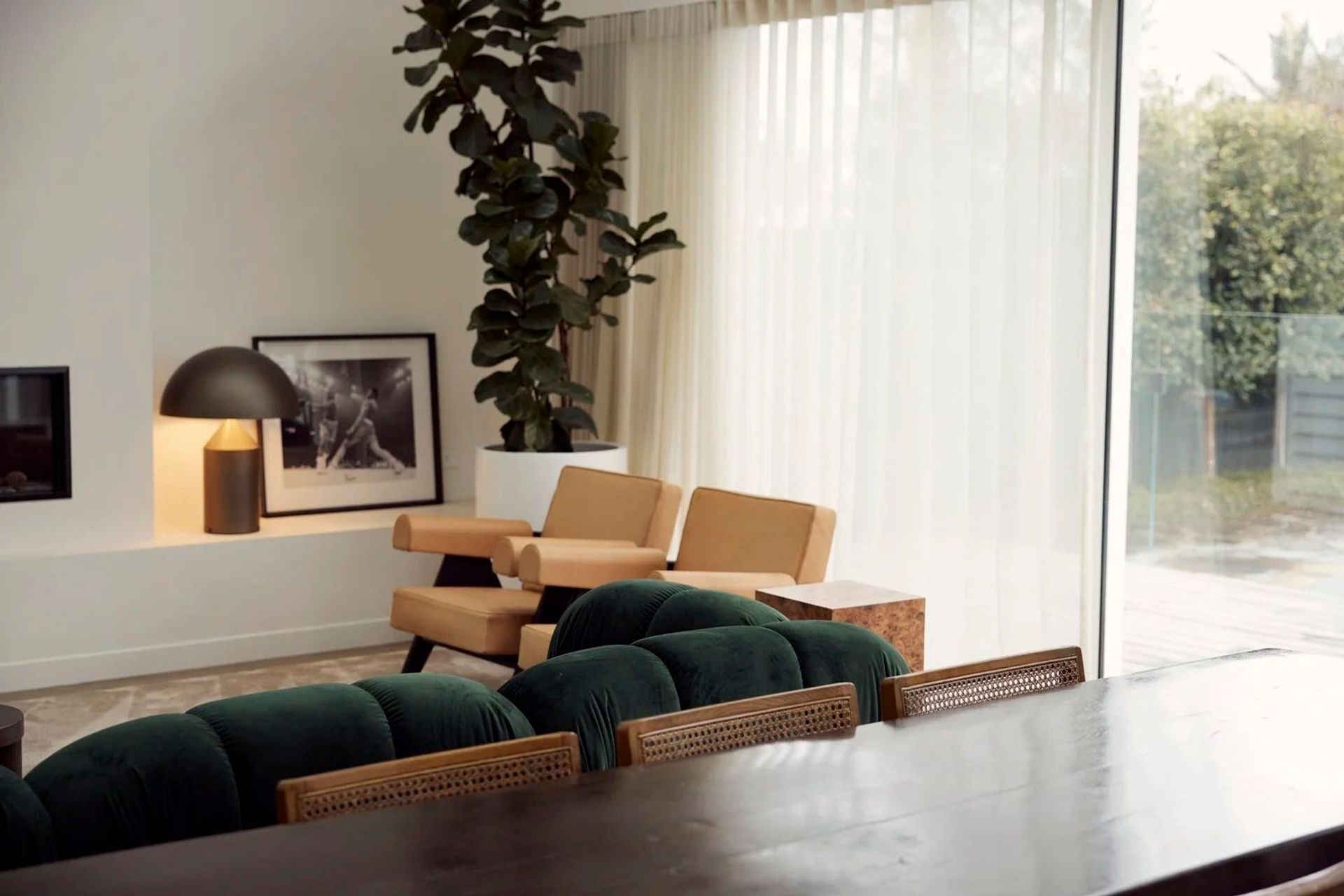 Point Chevalier bungalow open-plan living and dining area with floor-to-ceiling glazing, Pierre Jeanneret chairs and dark timber dining table — Macfie Architecture Auckland