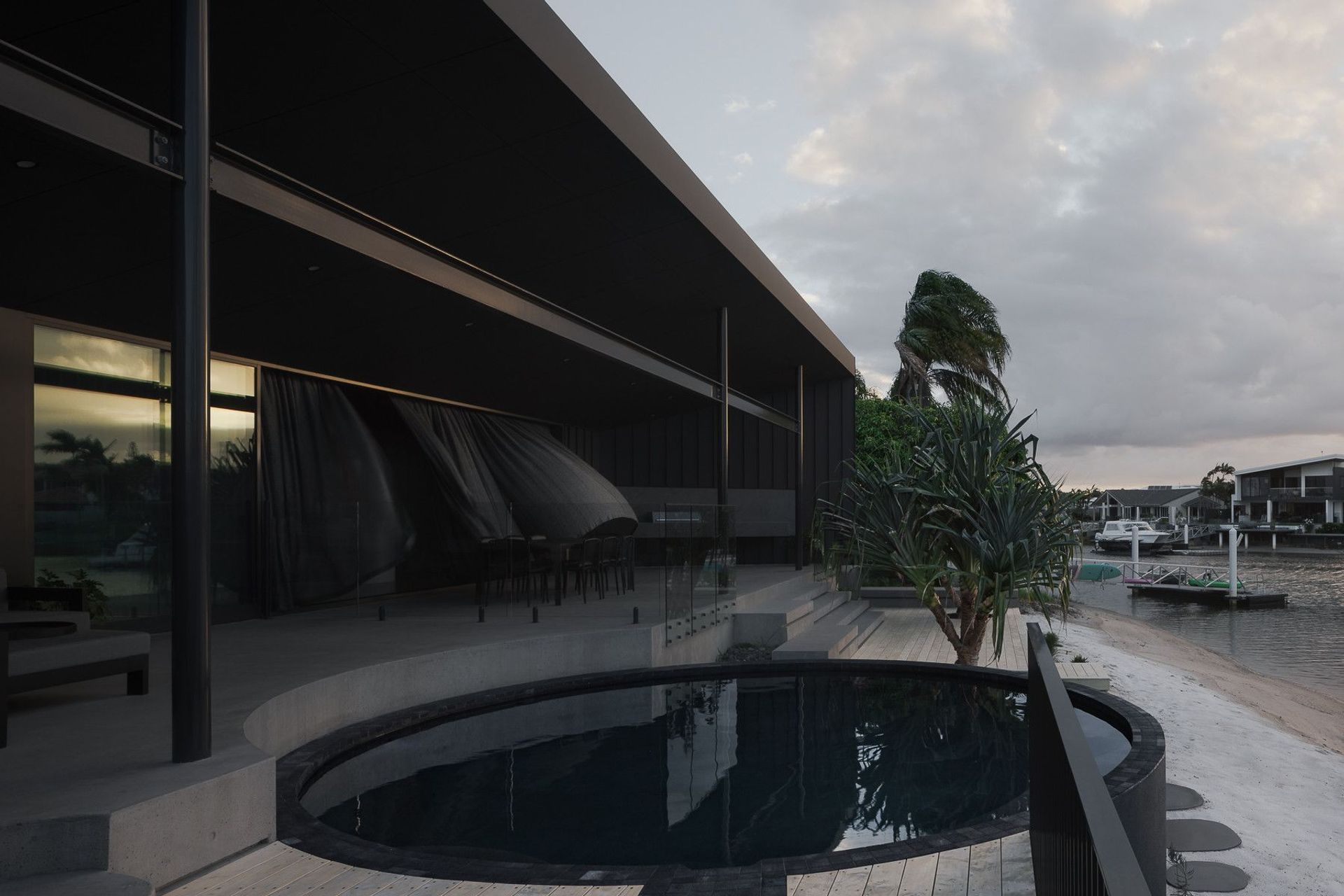0042 Residence - Pool. Circular plunge pool on the canal side terrace beneath a long roof.