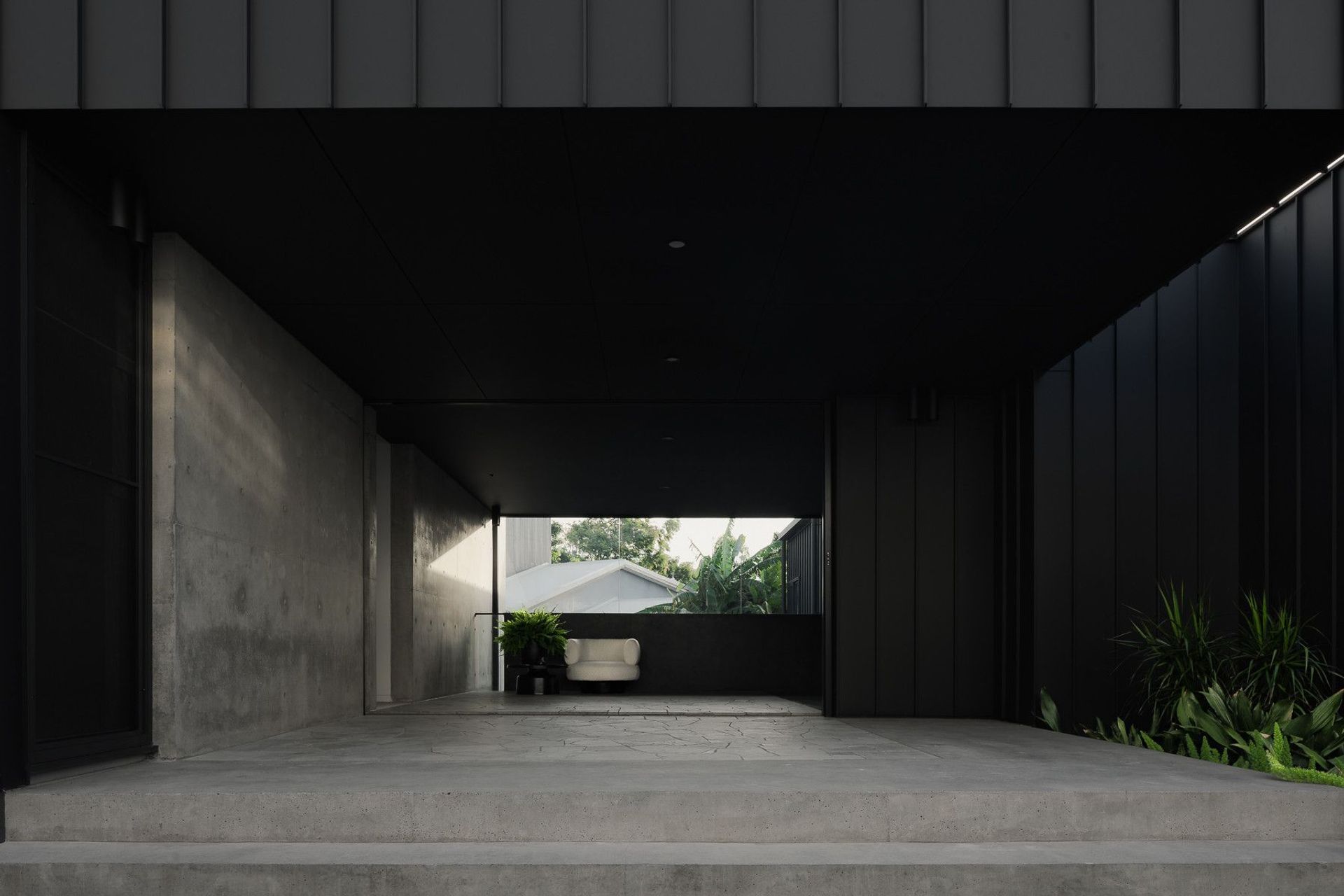0042 Residence - Entry. Covered entry passage framed by off-form concrete and dark cladding.
