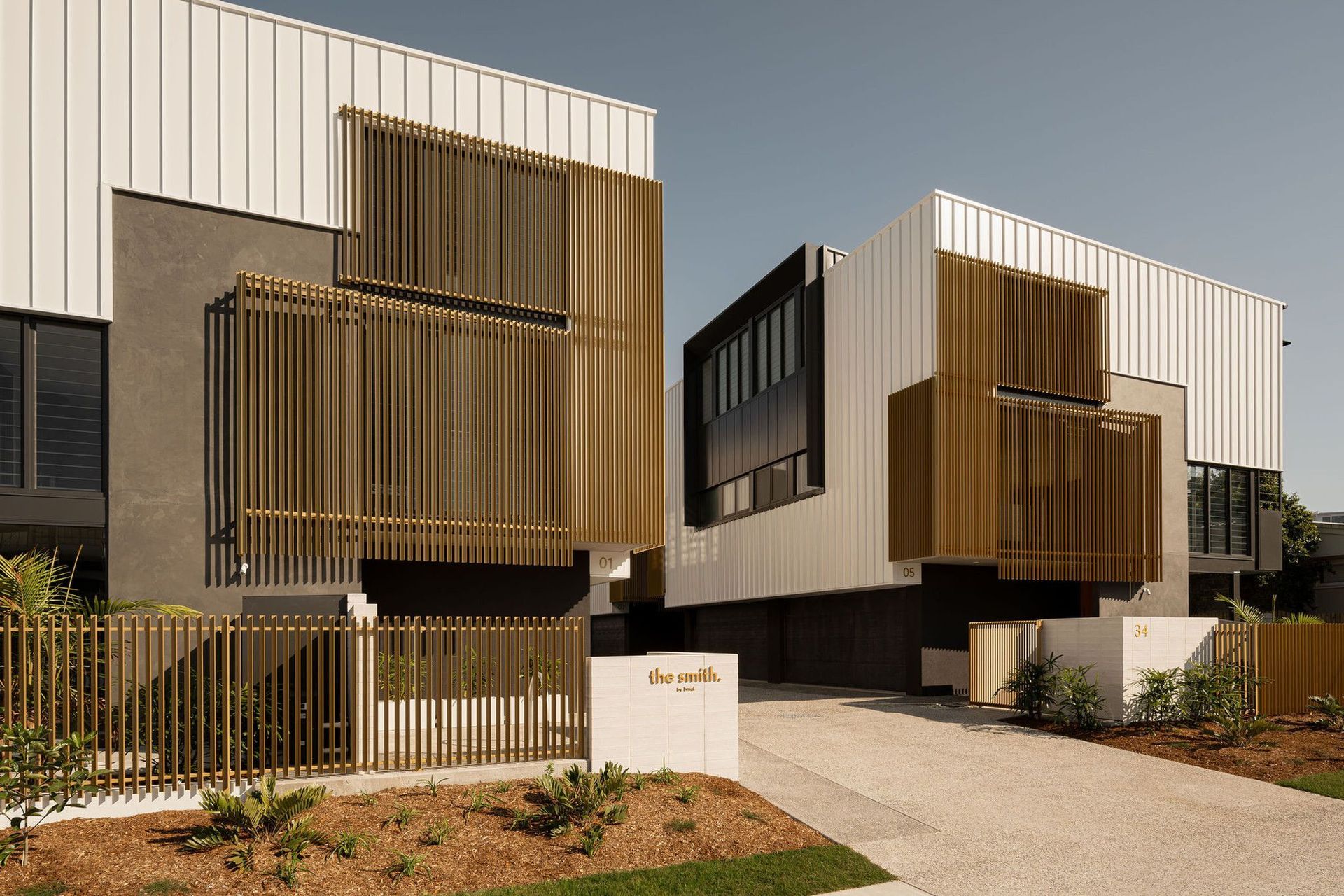 The Smith - Exterior. Street frontage with timber battened screens and a landscaped entry.