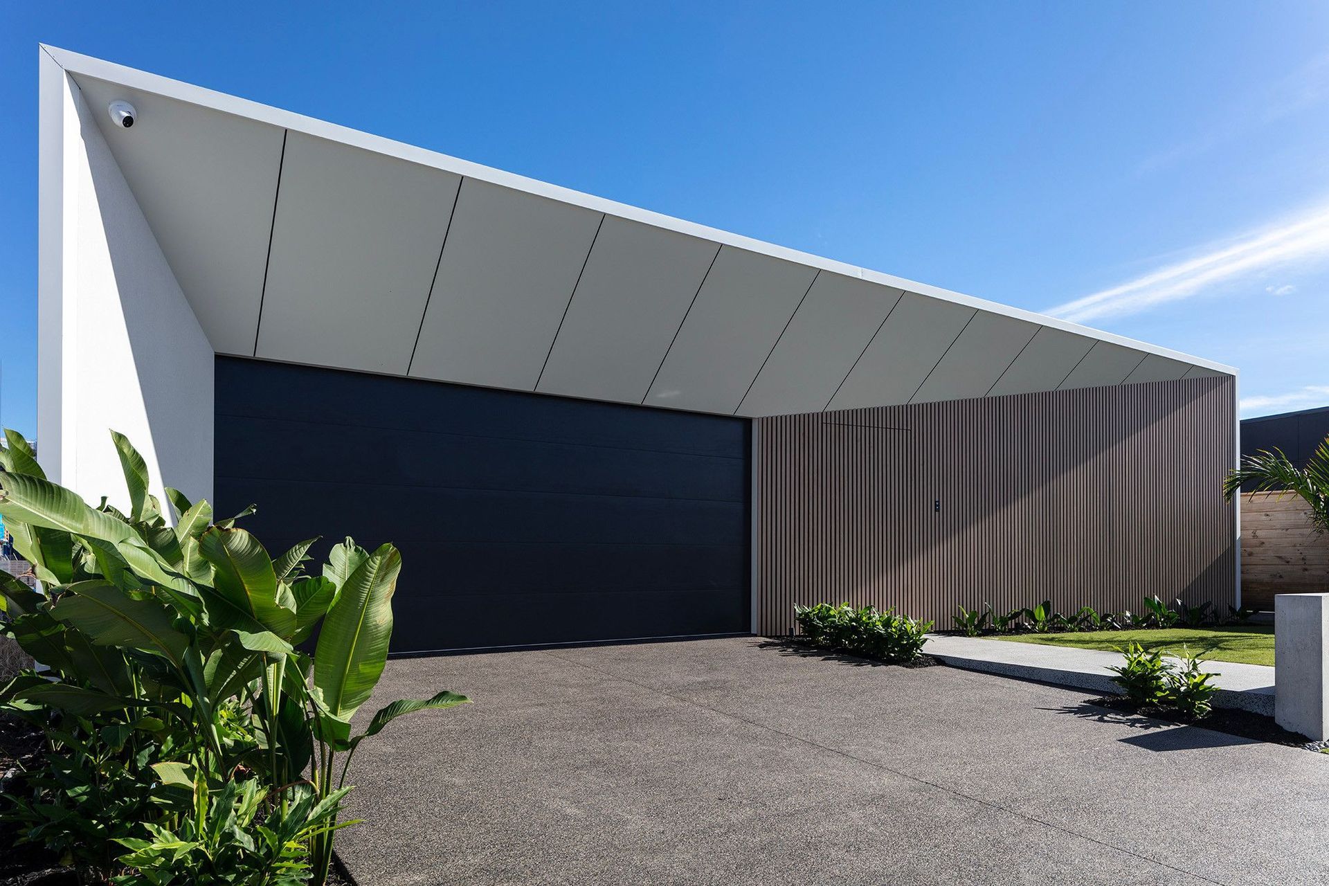 Bells Esplanade - Exterior. Charcoal garage door beneath an angled roof edge.