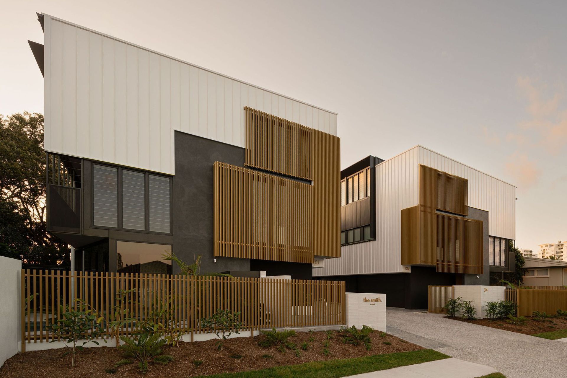 The Smith - Exterior. Townhouse facades with timber screens over dark cladding.