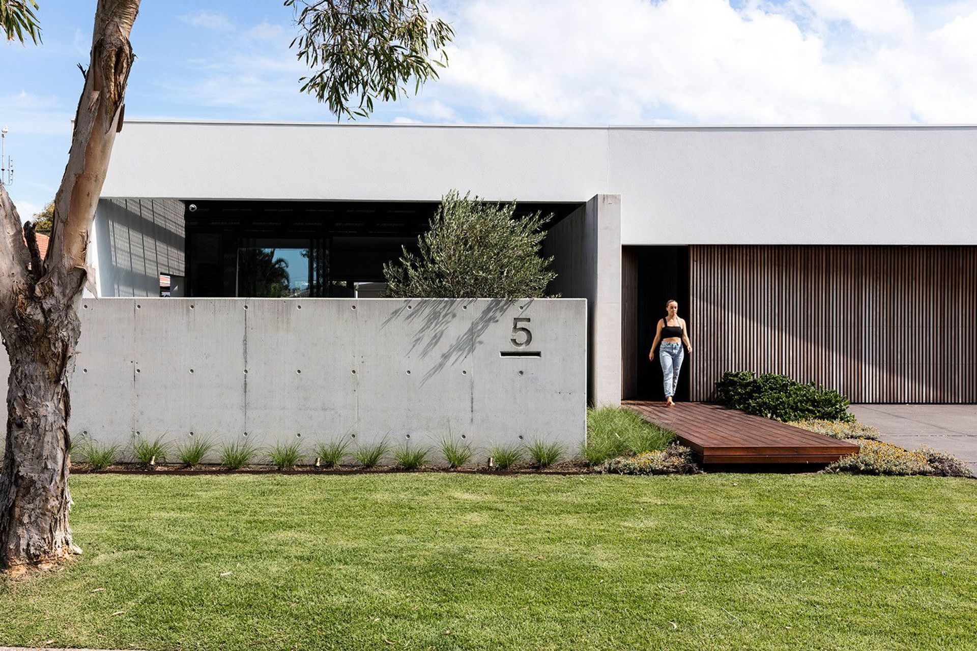 Morrison Residence - Exterior. Off-form concrete street wall and timber garage door.