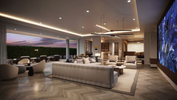 Luxurious open-plan living room with a large tufted sectional sofa, sculptural lounge chairs, layered area rug, warm concealed ceiling lighting, and contemporary linear pendant fixtures. The room features dark herringbone timber flooring, neutral upholstered furnishings, extensive glazing opening to an outdoor terrace, built-in shelving and bar-style joinery, and a large wall-mounted media display.