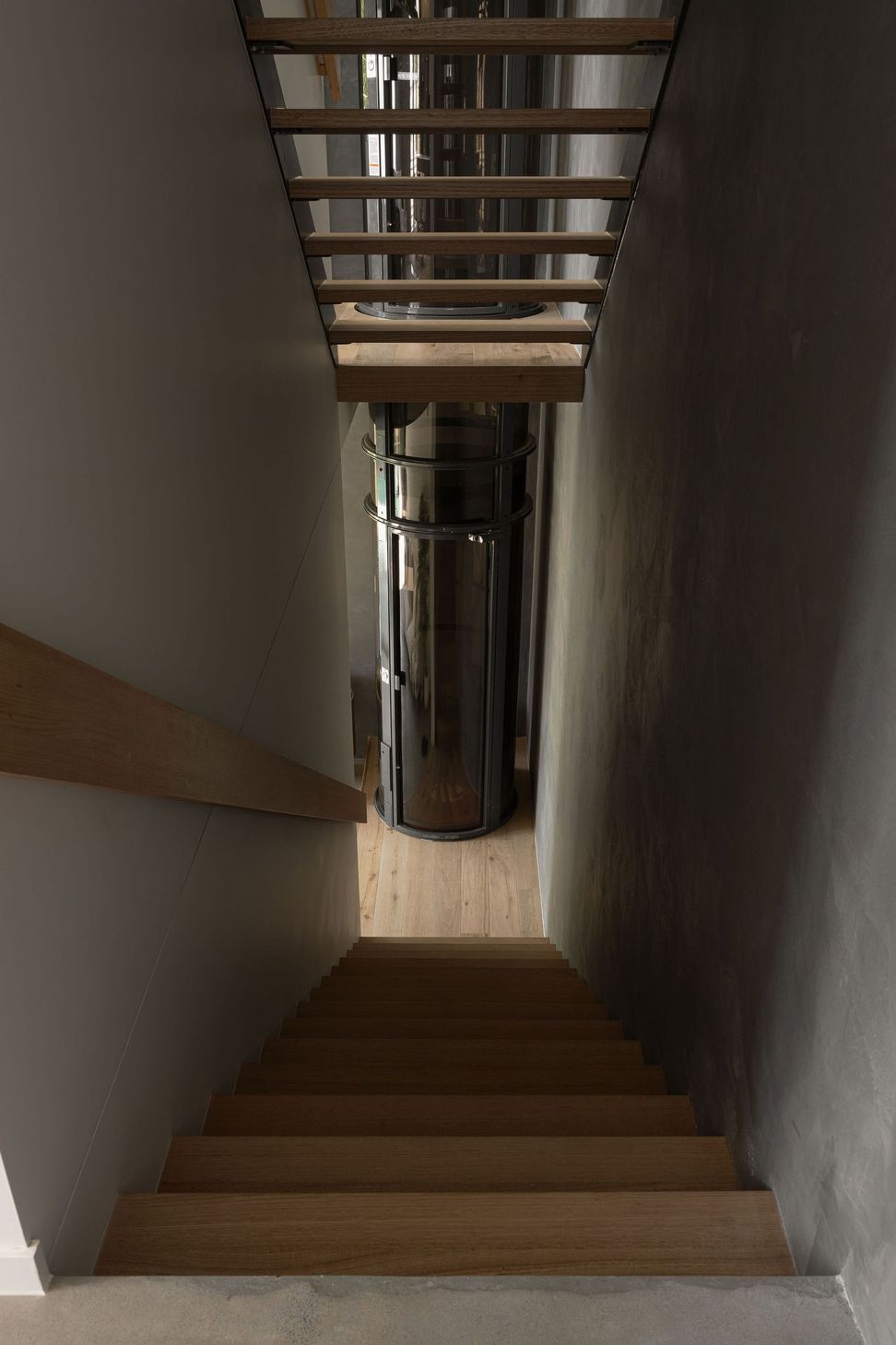 The Smith - Staircase. Timber stair rising through a dark shaft.