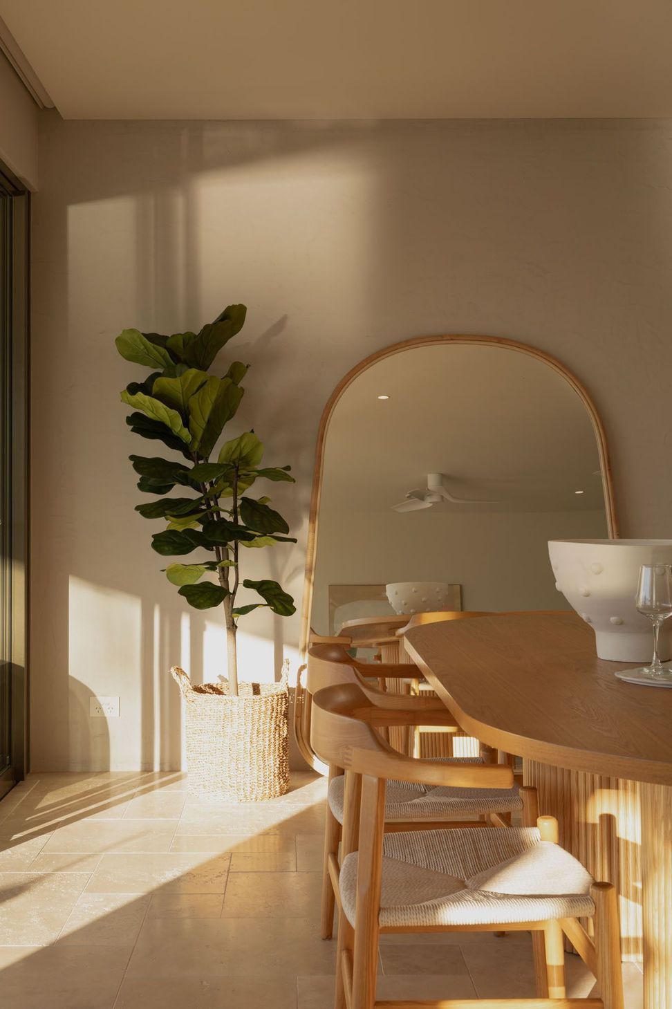 Warrego - Dining Room. Curved mirror and fiddle leaf fig beside the dining table.
