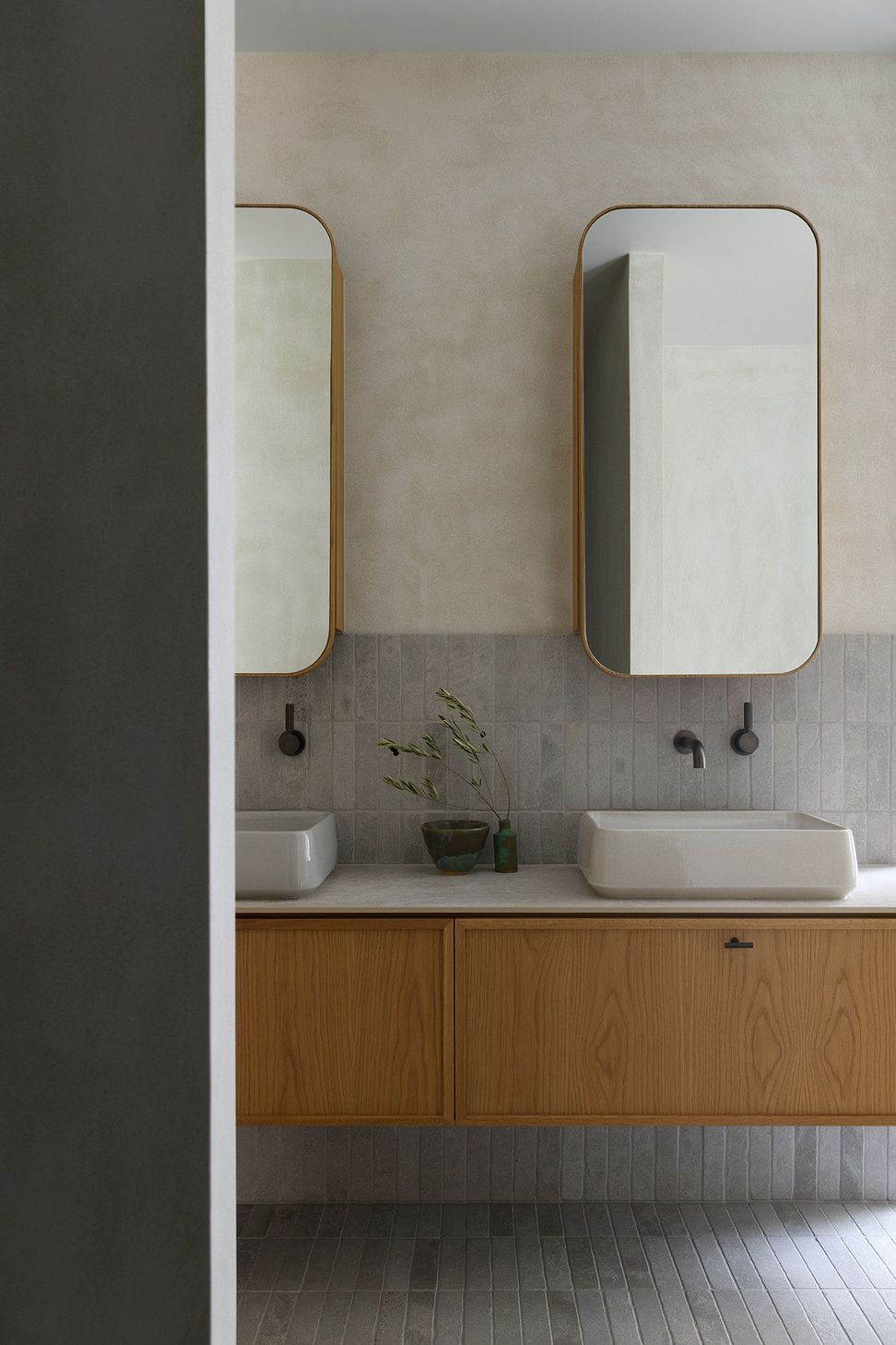 Villa Solare - Bathroom. Curved timber vanity beneath a rounded mirror.